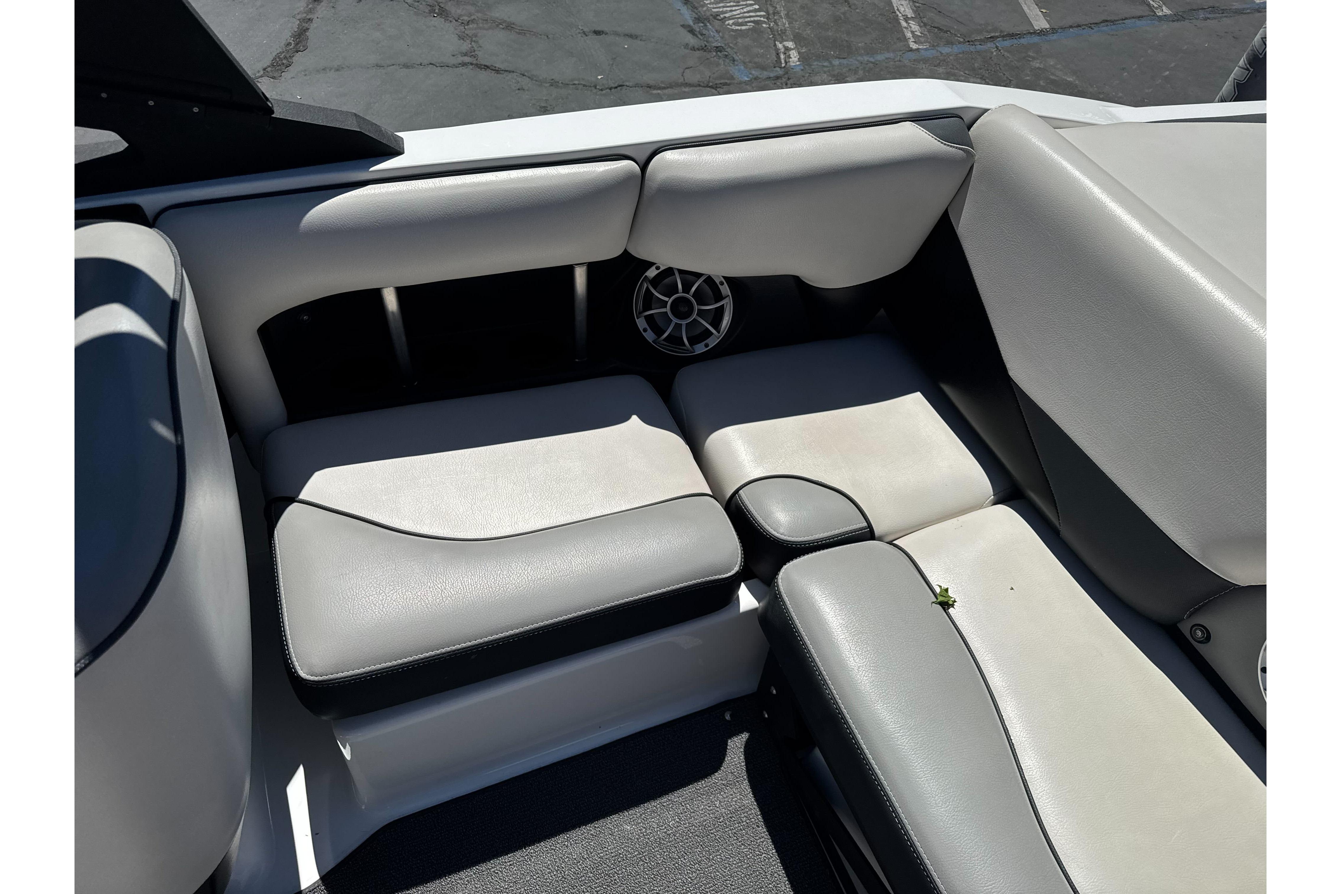 Interior seating of a 2015 Axis A20 boat, featuring gray upholstery and a speaker.