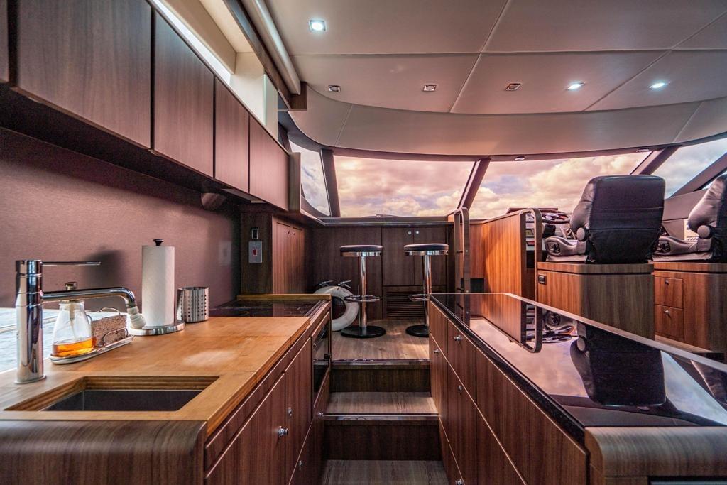 Luxurious interior of 2020 Fairline 68 yacht with modern kitchen and seating area.