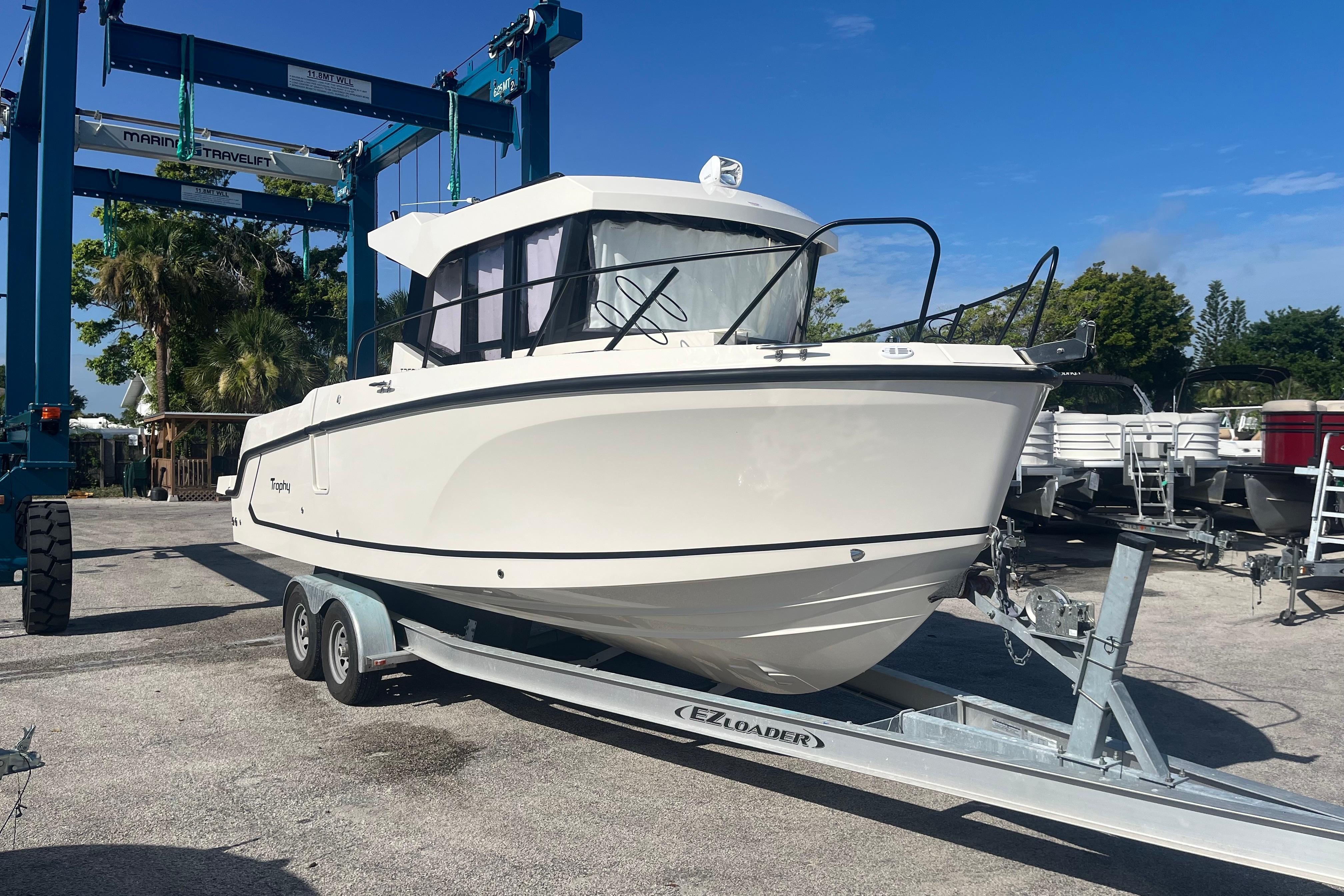 2025 Bayliner Trophy T25 Pilothouse boat on trailer under clear blue sky.
