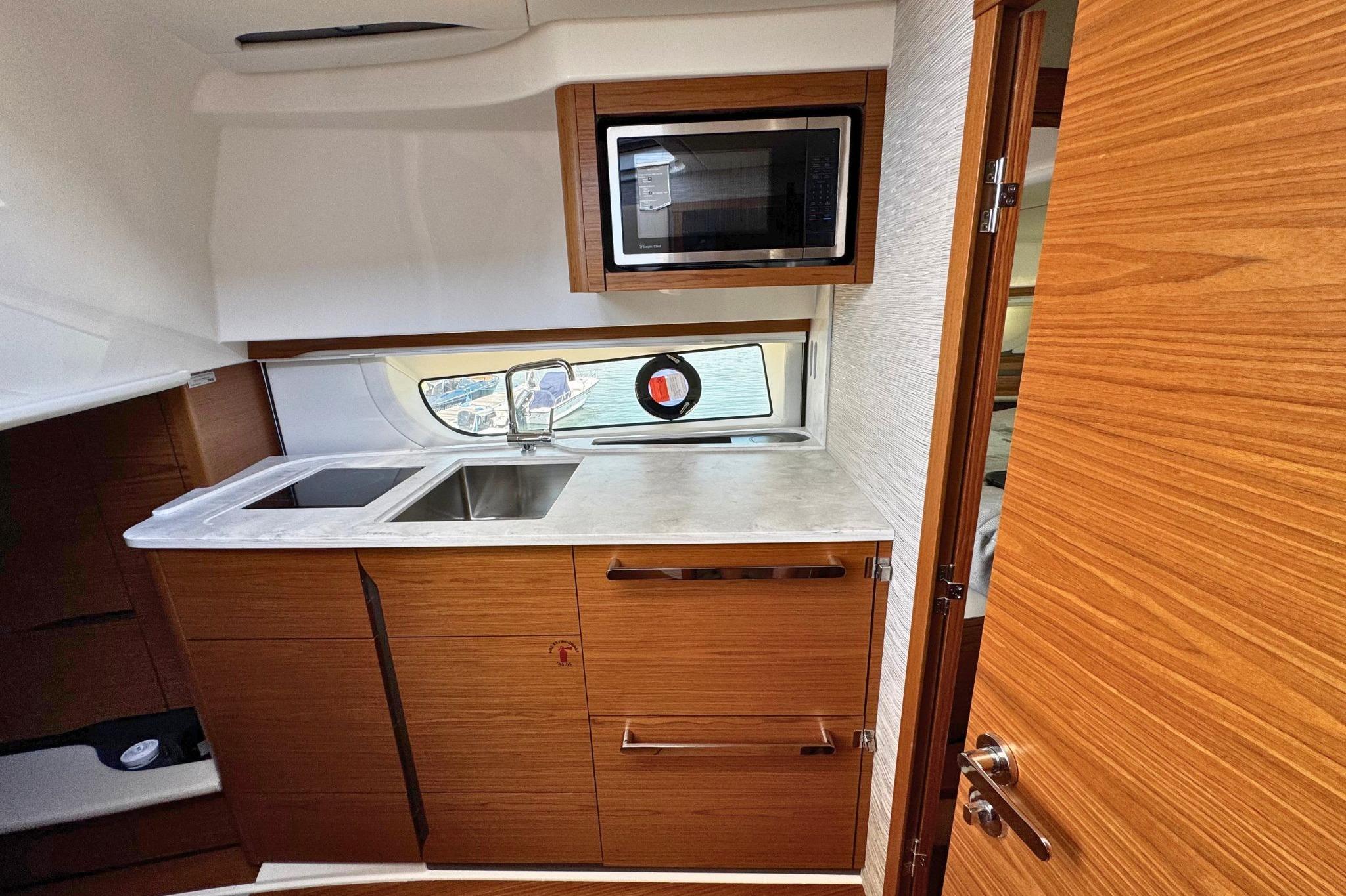 Modern kitchen interior of 2027 Tiara Yachts 39 LE with wood cabinetry and stainless steel sink.