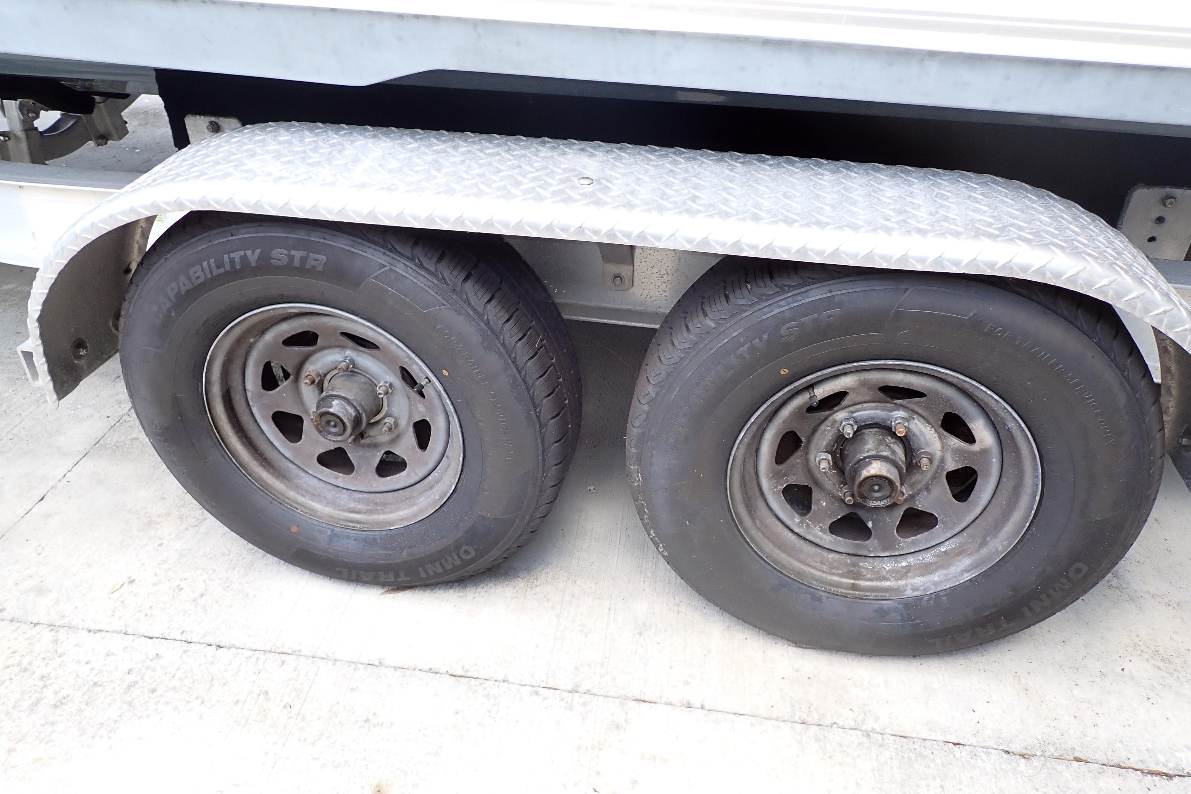Trailer wheels of a 2019 Key West 263 FS boat on a concrete surface.