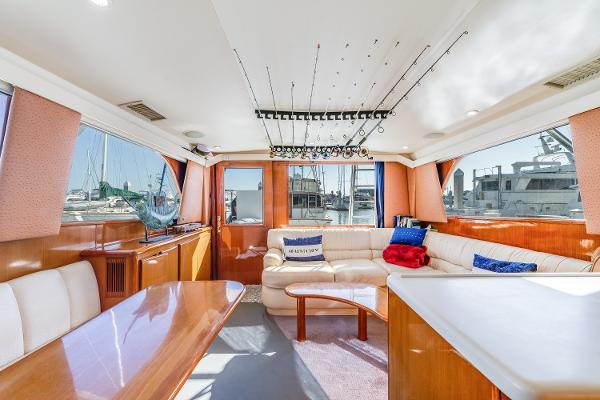 Luxurious interior of a 1999 Viking 47 Convertible yacht with plush seating and fishing rods.