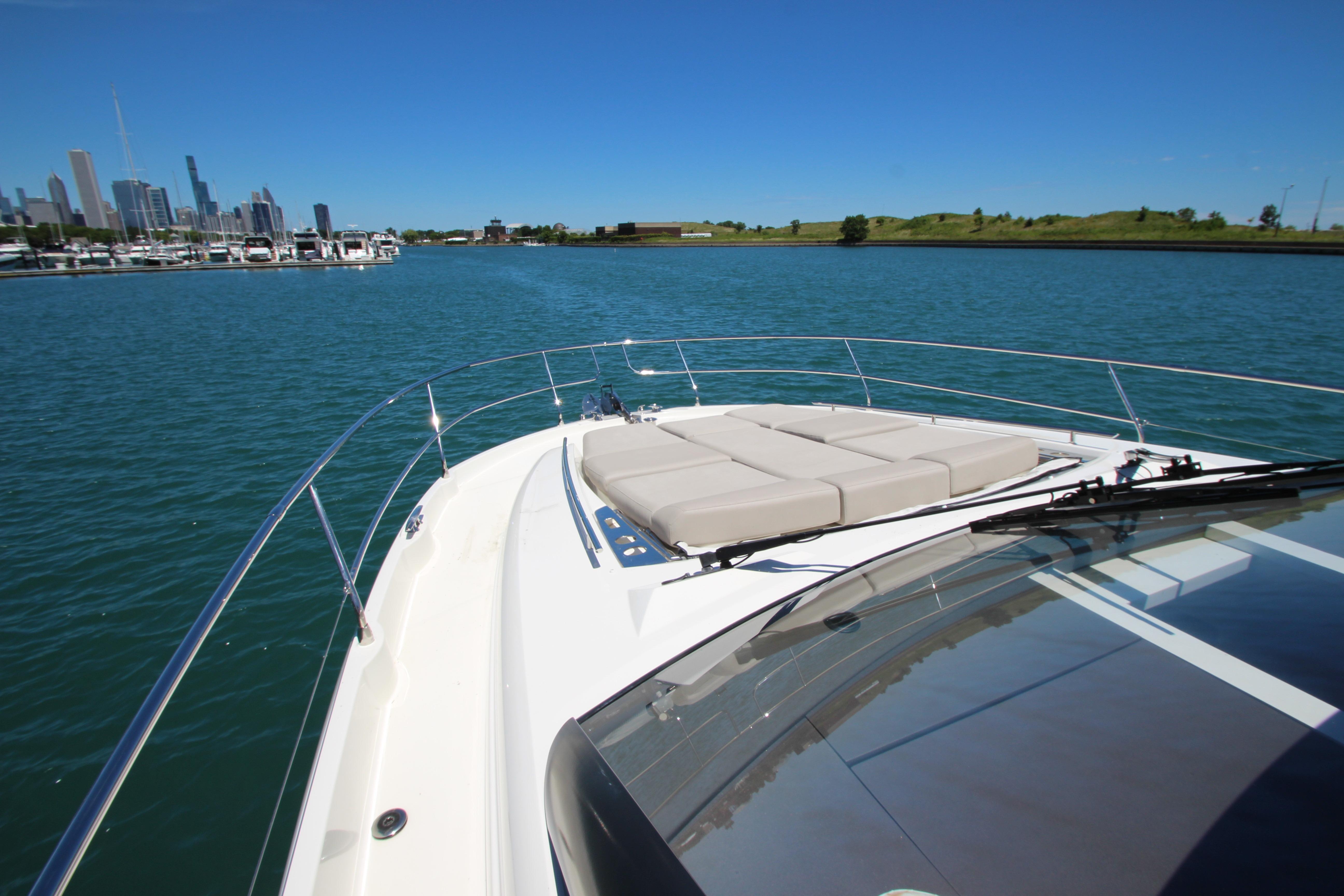 Prestige 520 yacht cruising near city skyline, 2022 model.