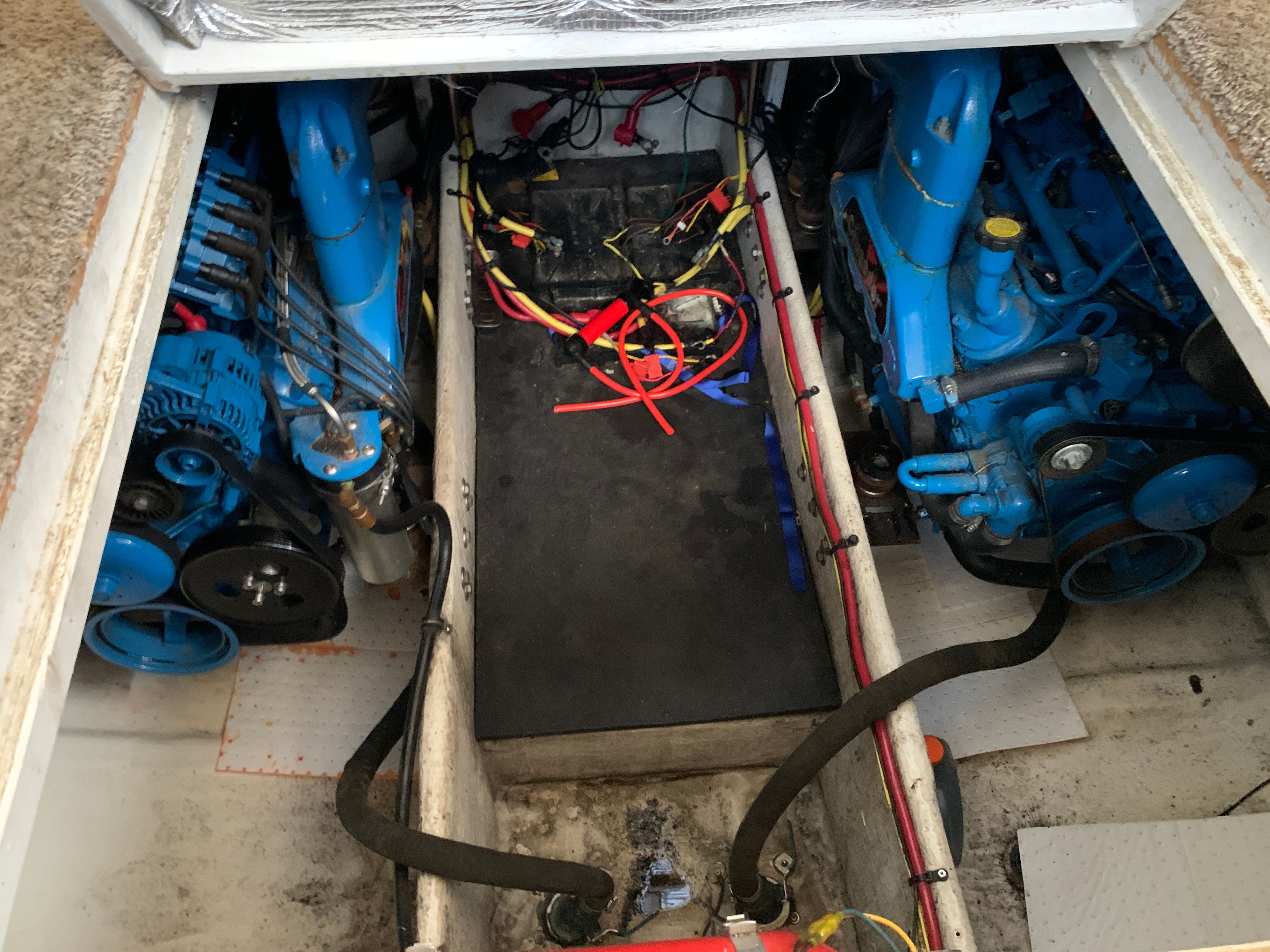 The engine compartment of a Silverton 33 Convertible boat with blue engines and wiring.