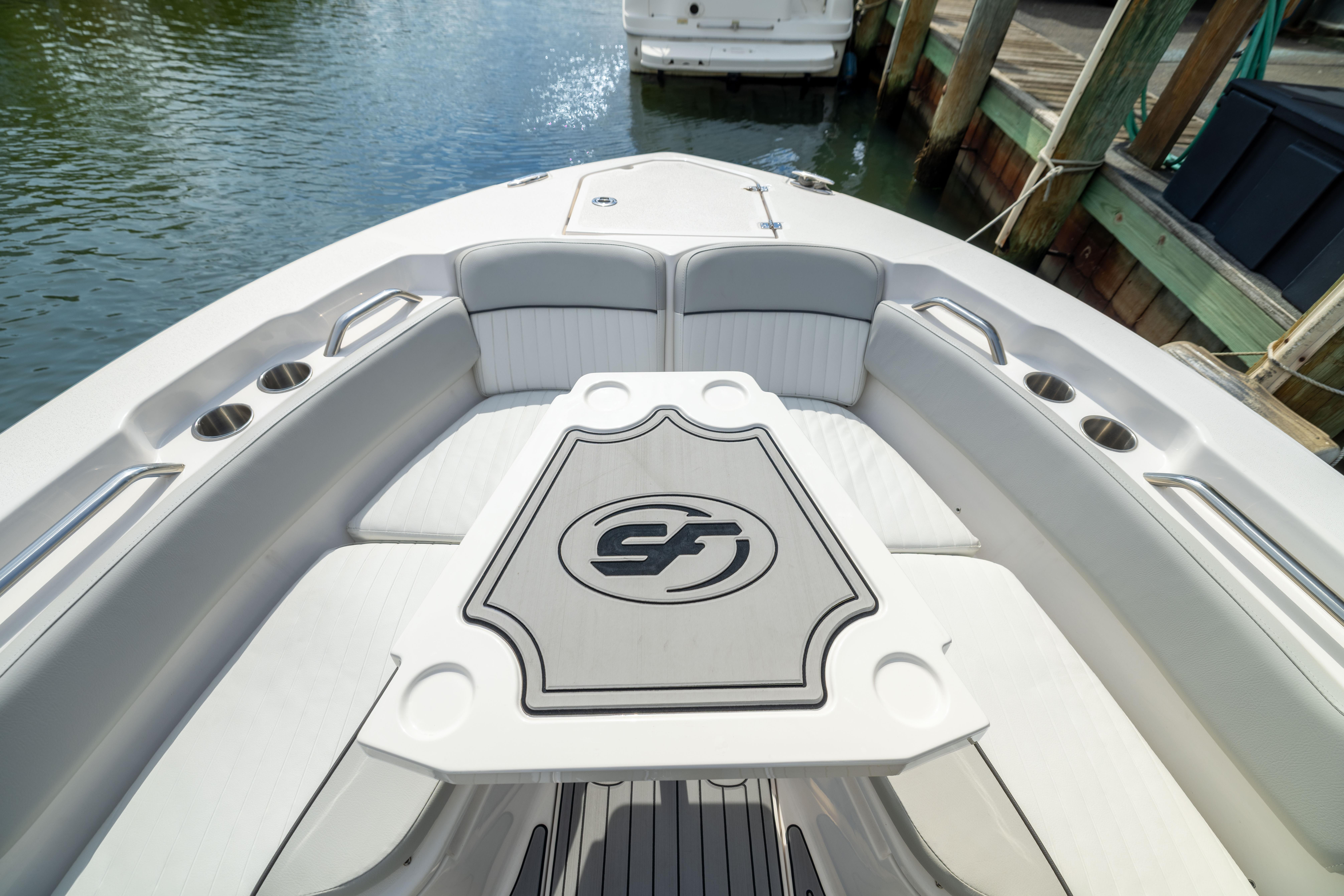 2023 Sea Fox 228 Commander boat interior with seating and table, docked by the water.