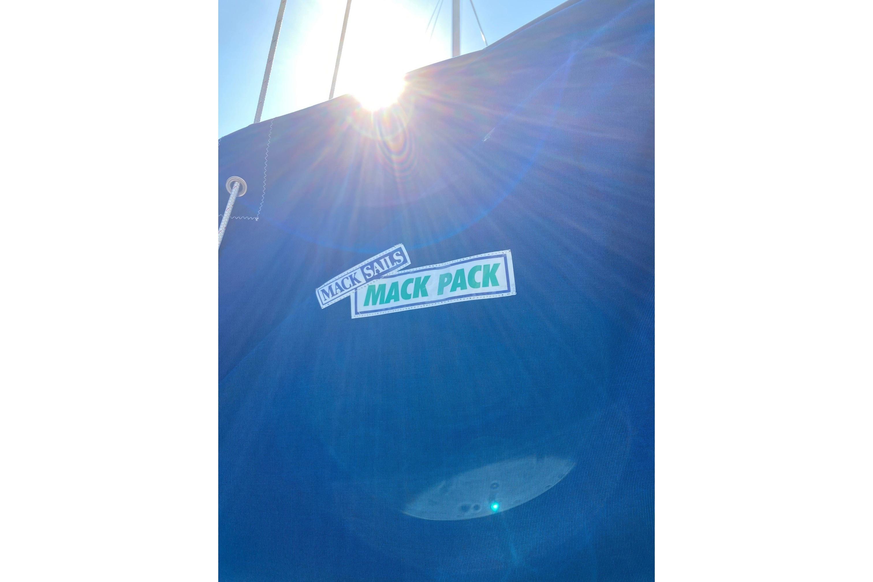 Blue sail cover with "Mack Sails Mack Pack" logo, sunlight shining through. Sabre 30, 1982.
