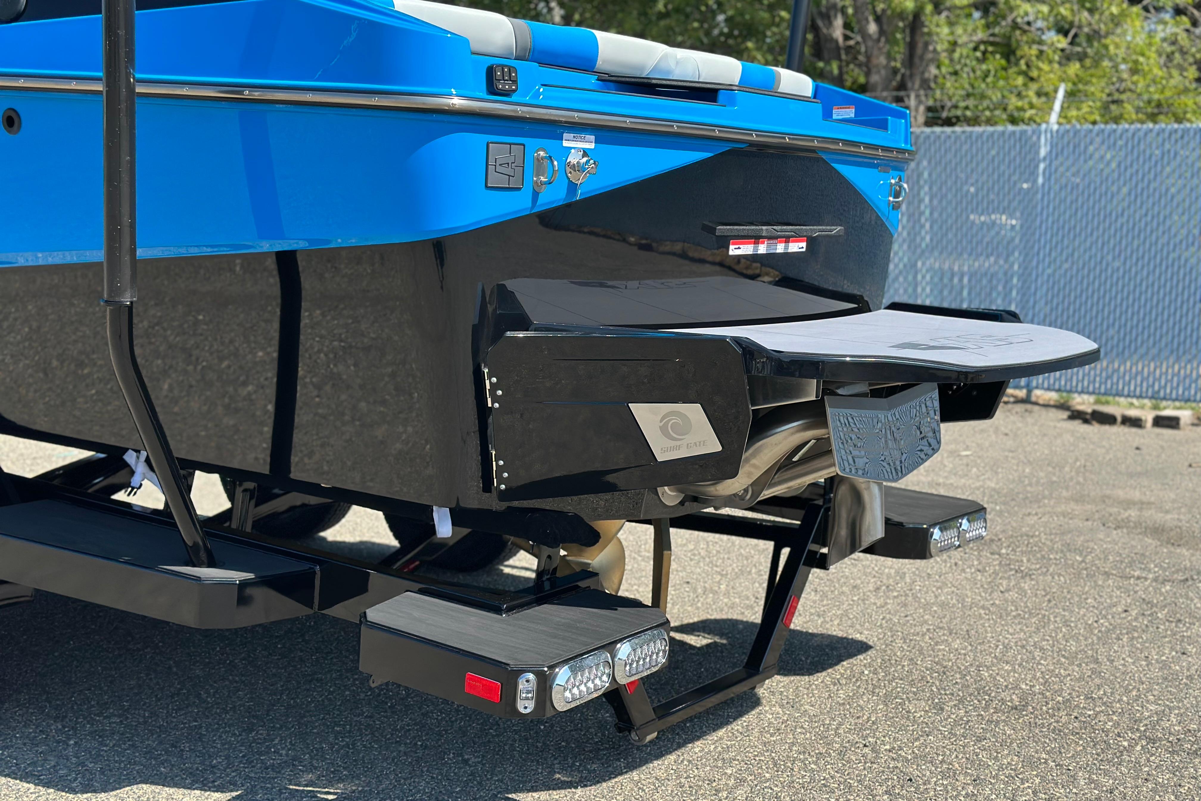 2026 Axis T235 boat rear view with blue and black design, featuring swim platform.