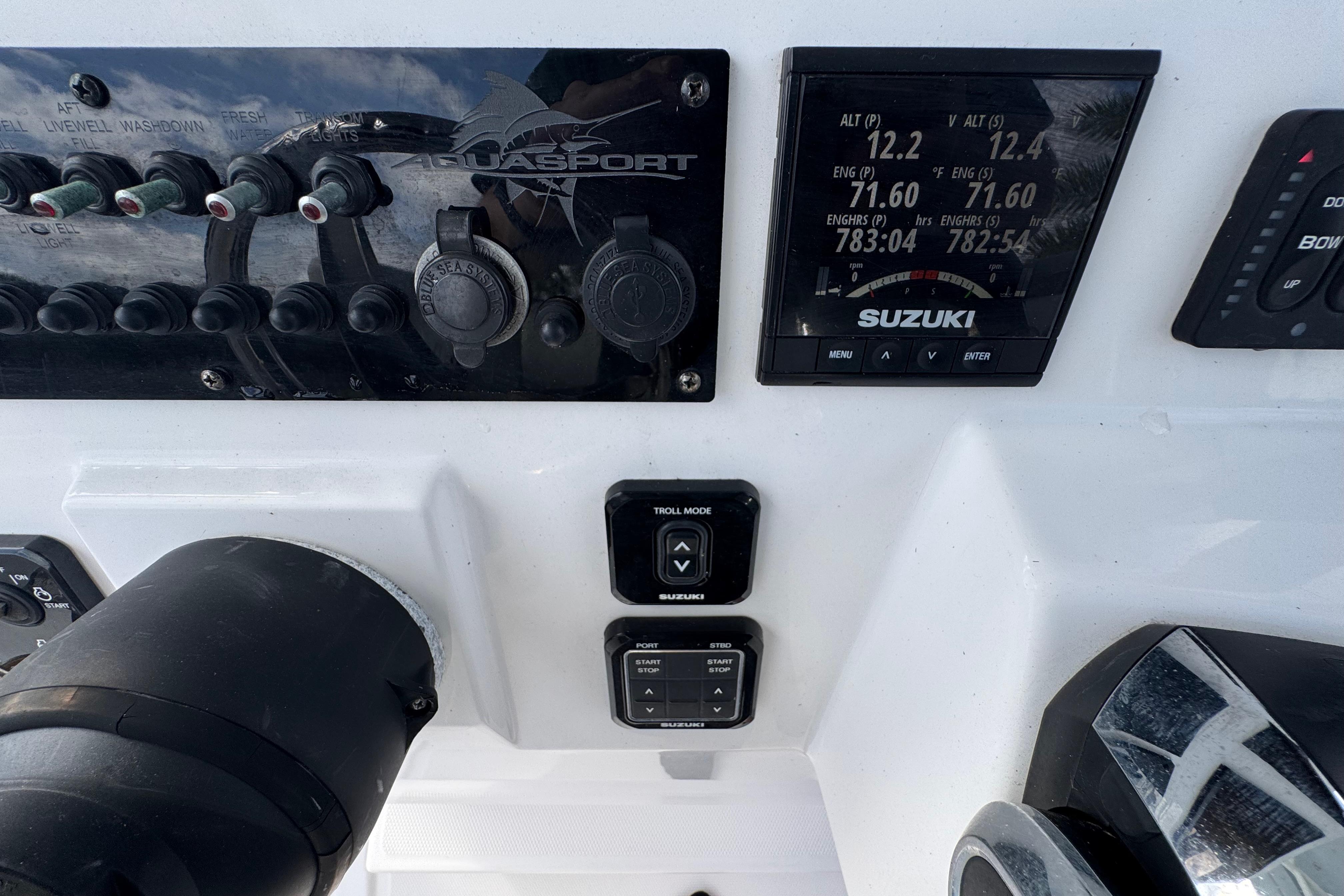 Control panel of 2022 Aquasport 2500 Center Console with Suzuki display and switches.