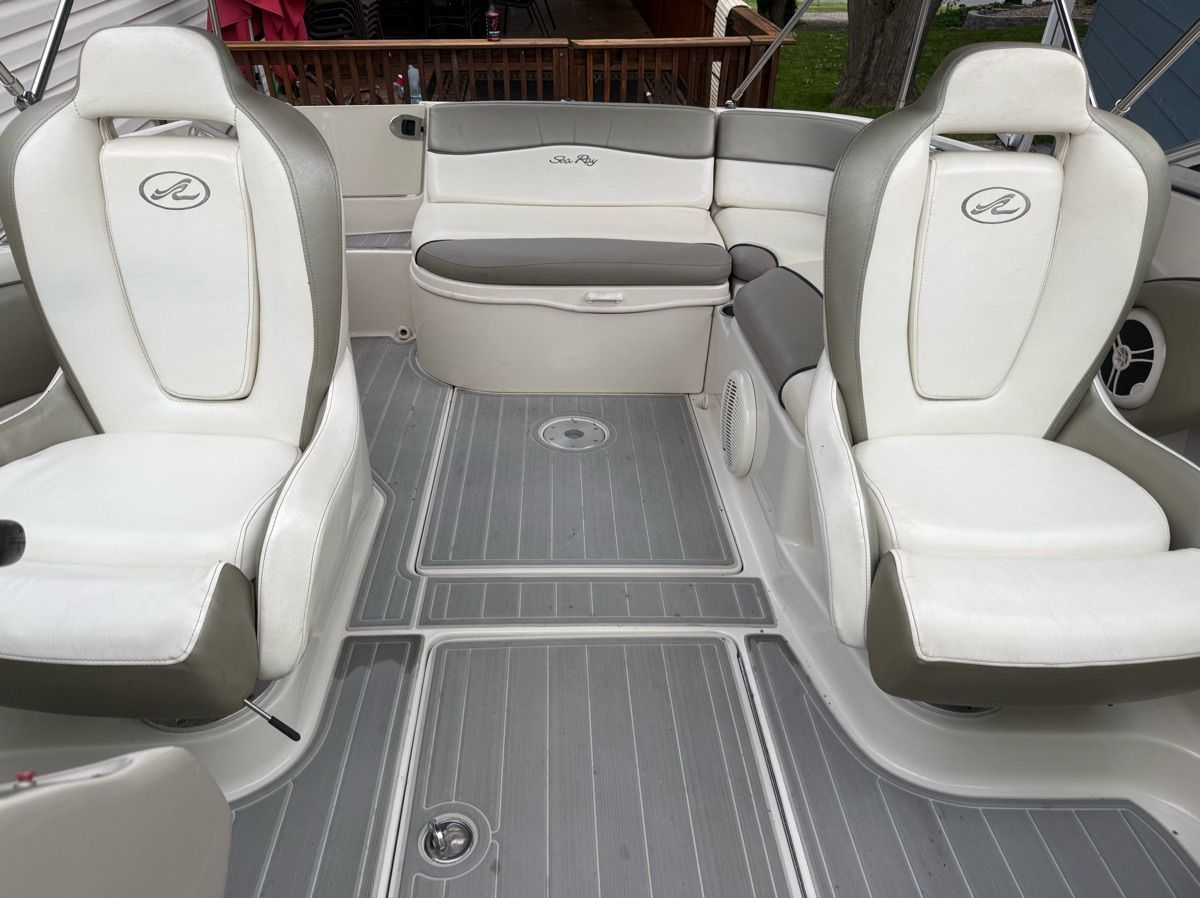 Interior of a 2007 Sea Ray 240 Sundeck with white and gray seating and gray flooring.