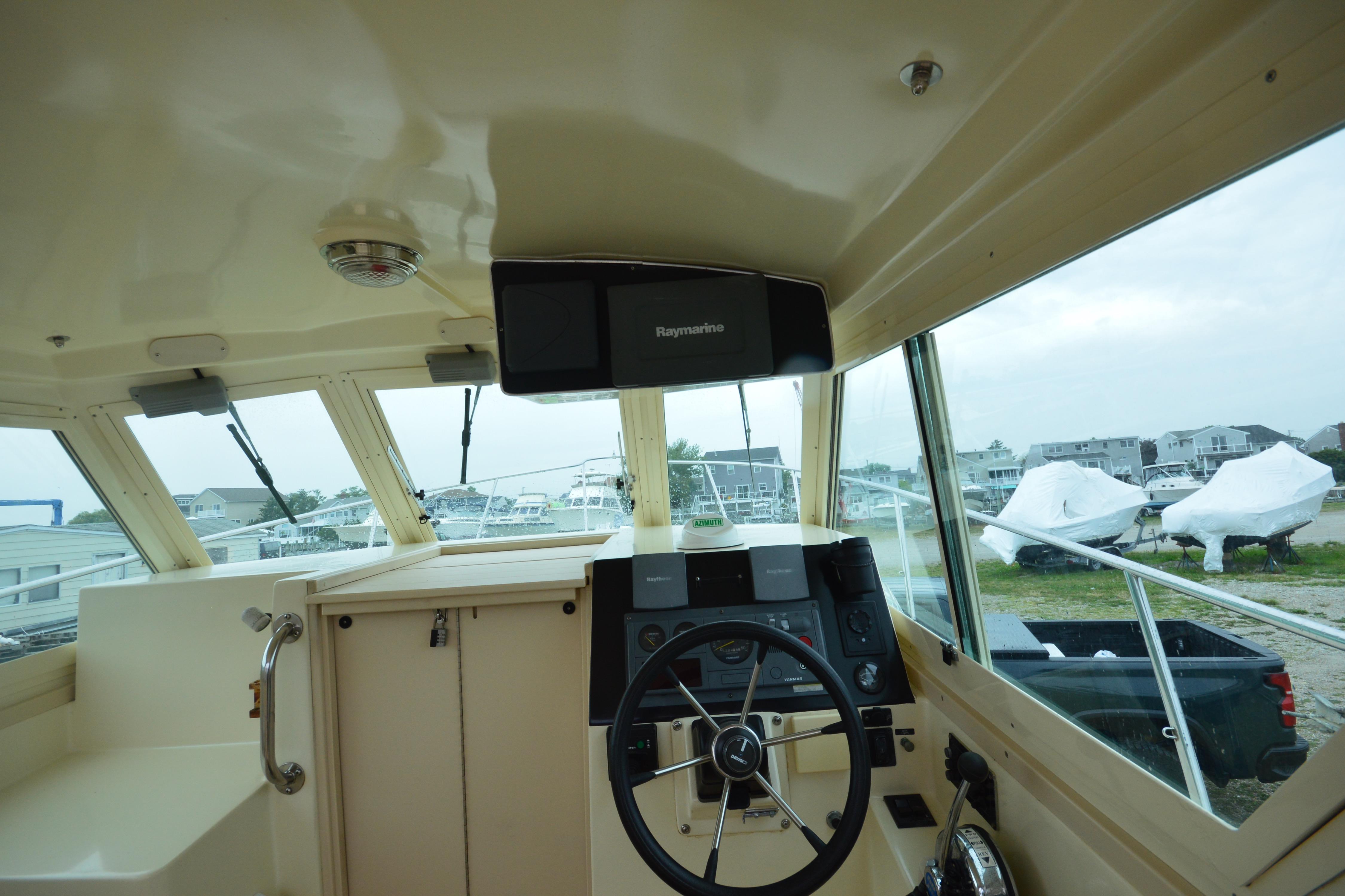 2001 Albin 28 Tournament Express helm with Raymarine electronics, overlooking marina and boats.