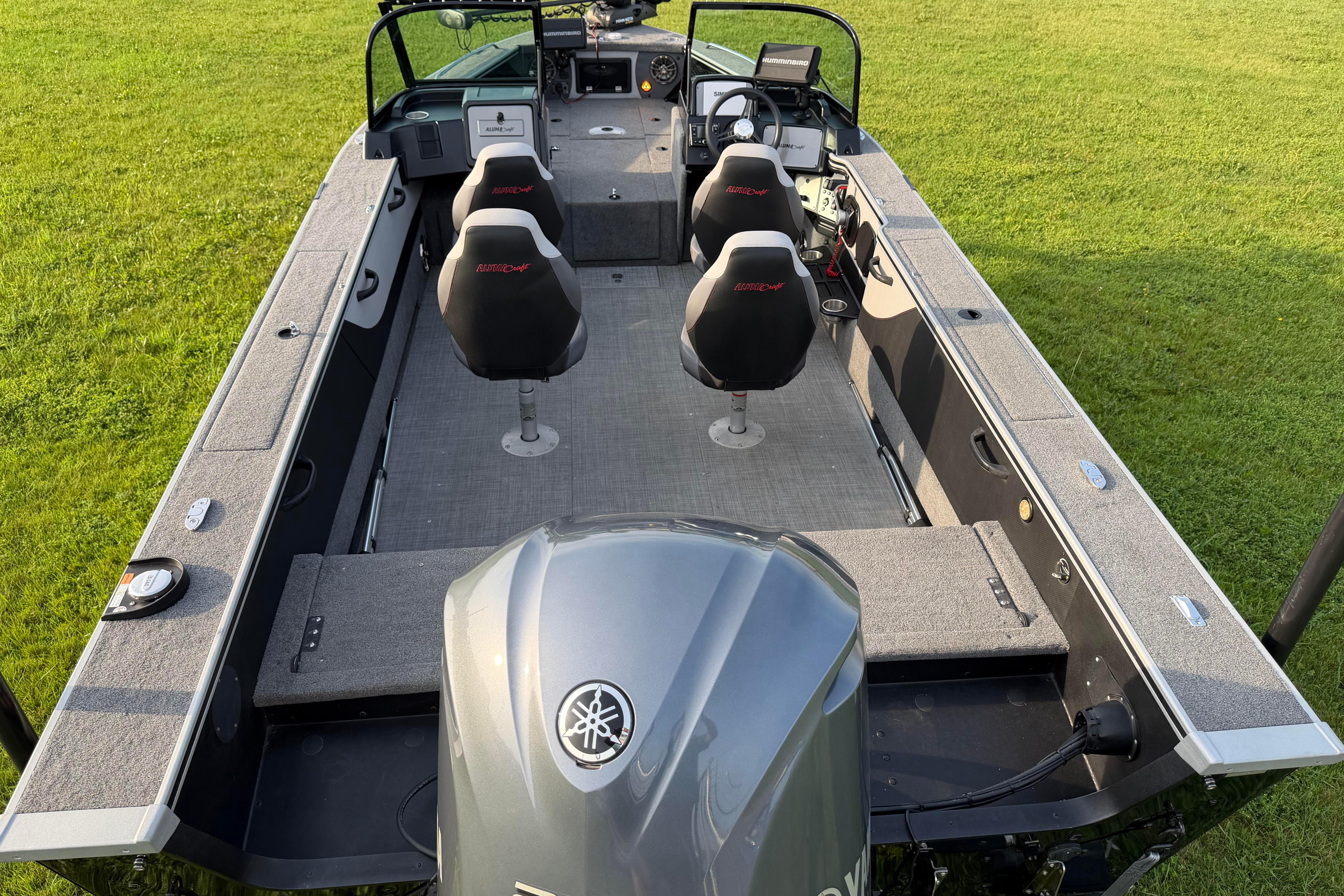 2019 Alumacraft Trophy 205 boat interior with seating and controls, on grassy background.