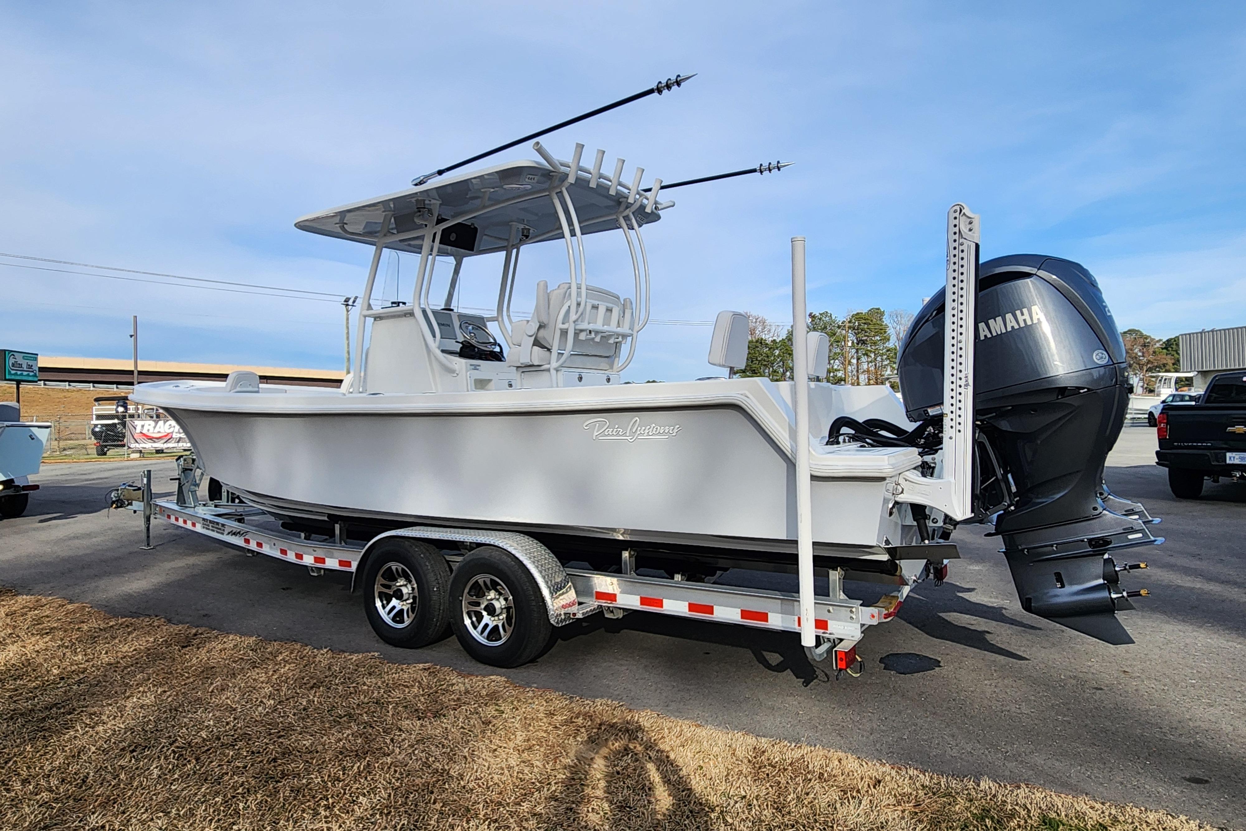 2024 Pair Customs 27 CC boat on trailer with Yamaha engine, parked outdoors.