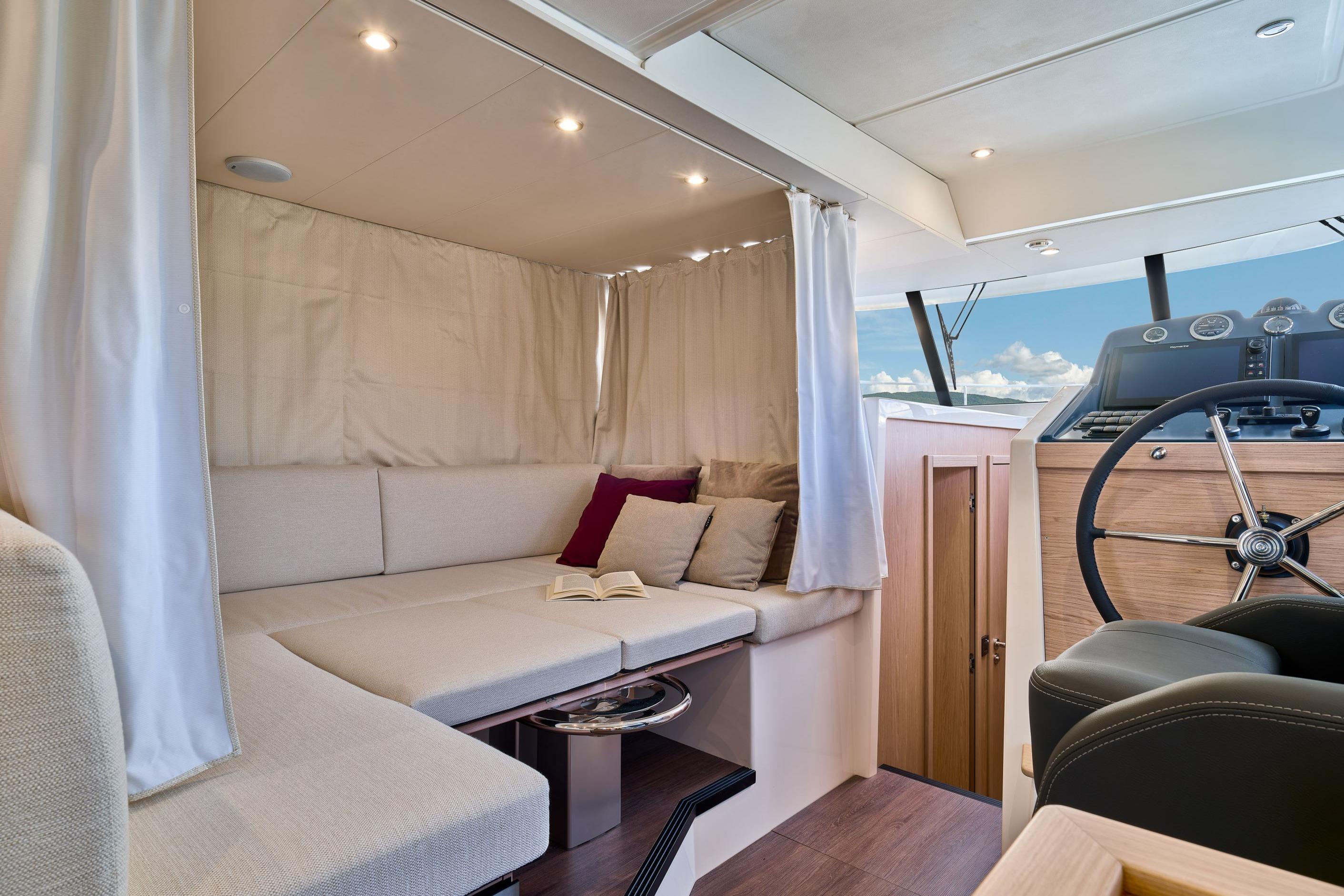 Interior of 2026 Beneteau Swift Trawler 48, featuring cozy seating and helm station.