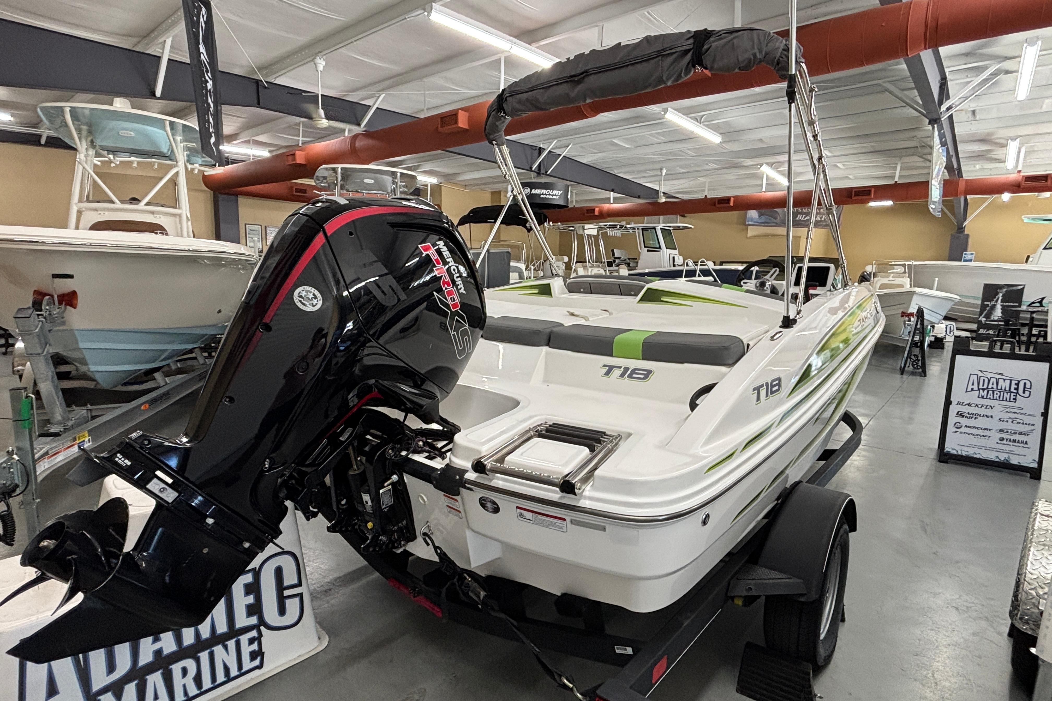 2024 Tahoe T18 boat with powerful outboard motor displayed in a showroom.