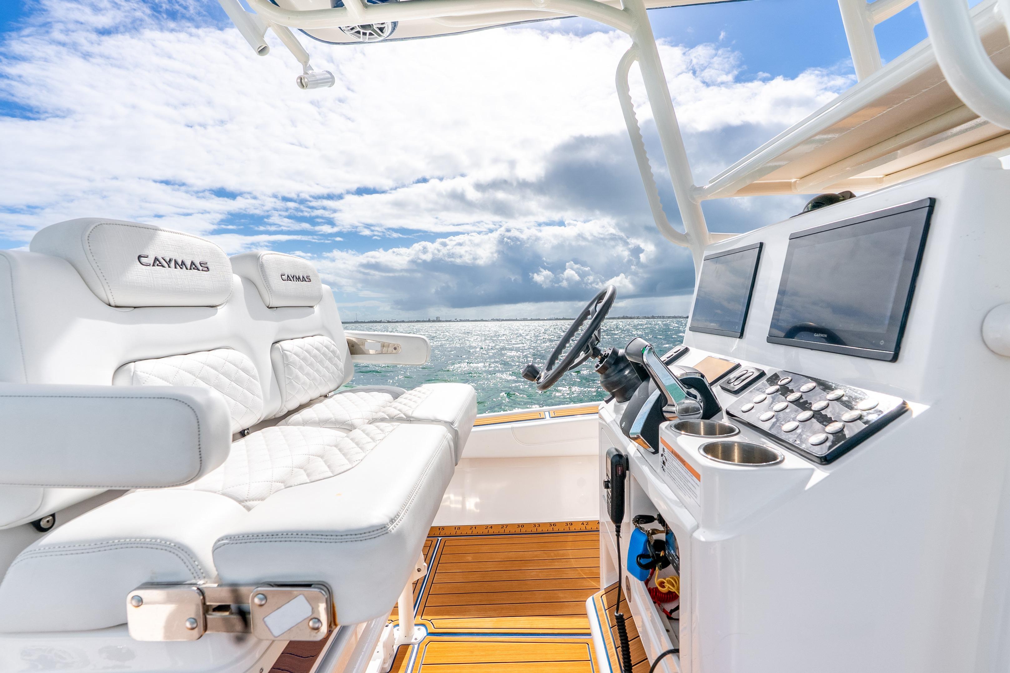 2024 Caymas 281 HB boat interior with helm, dual screens, and luxurious seating.