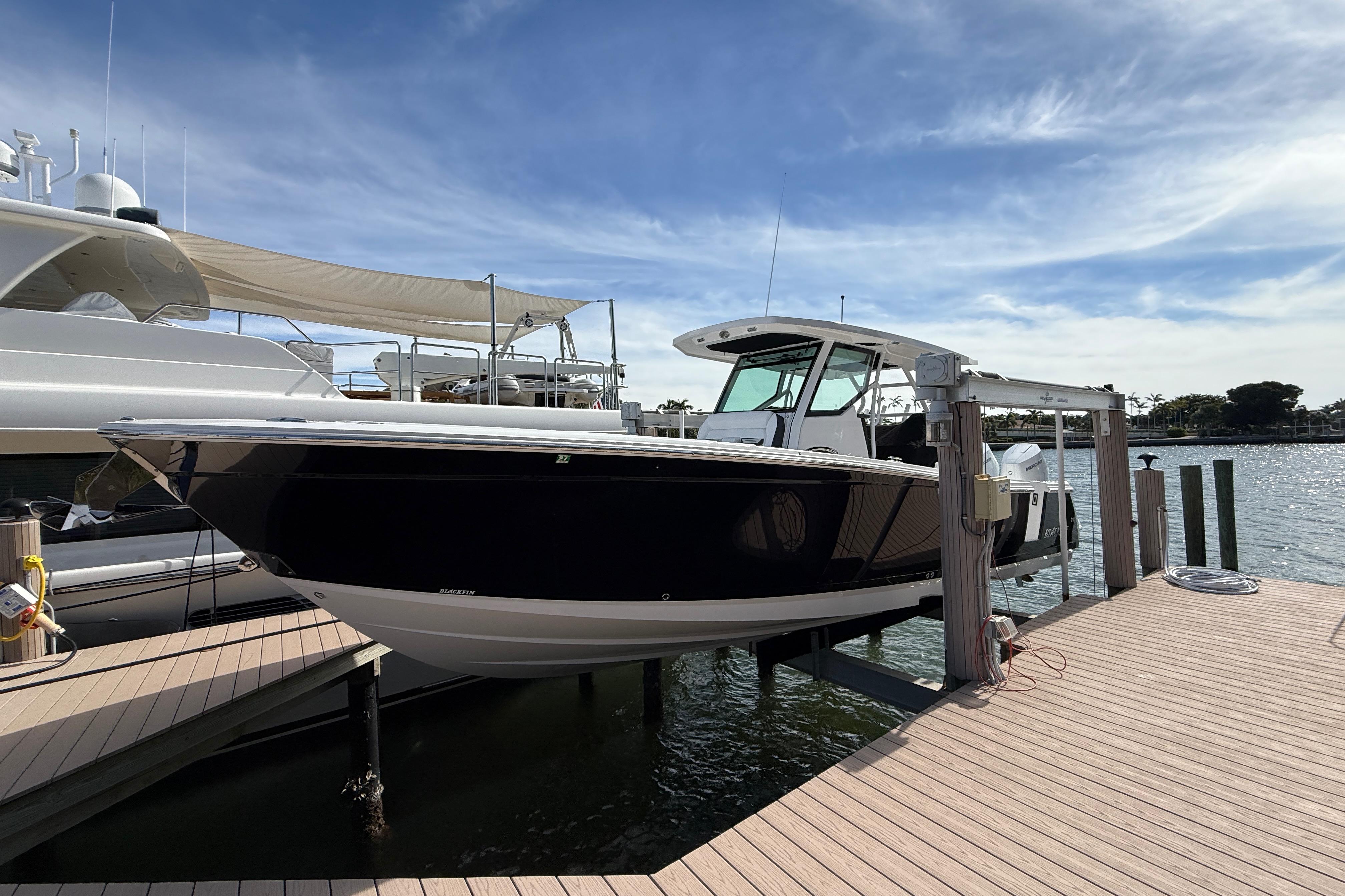 2026 Blackfin 332 CC boat docked under a clear blue sky.