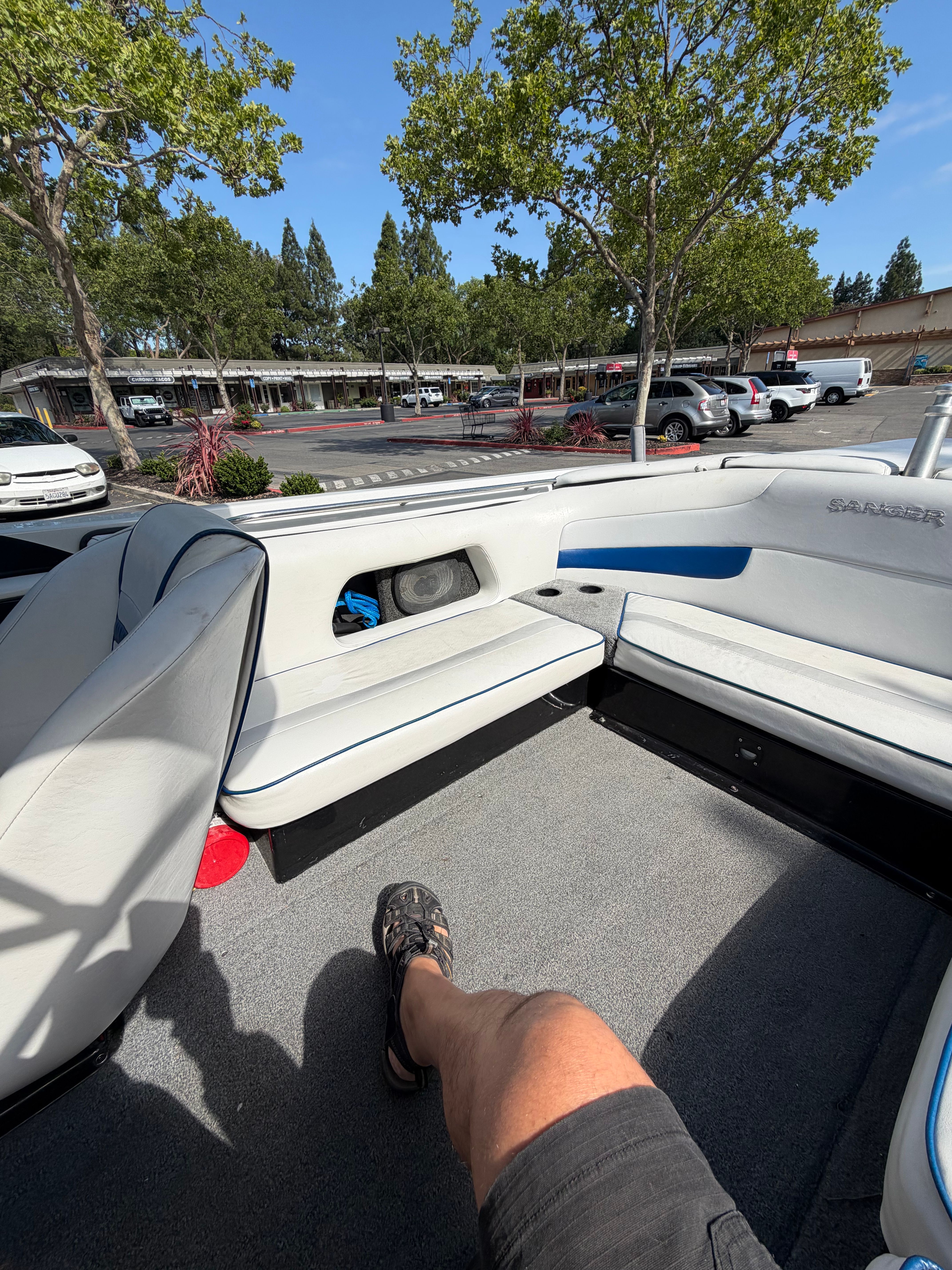 Interior view of a 2001 Sanger V210 boat with gray carpet and white seating.