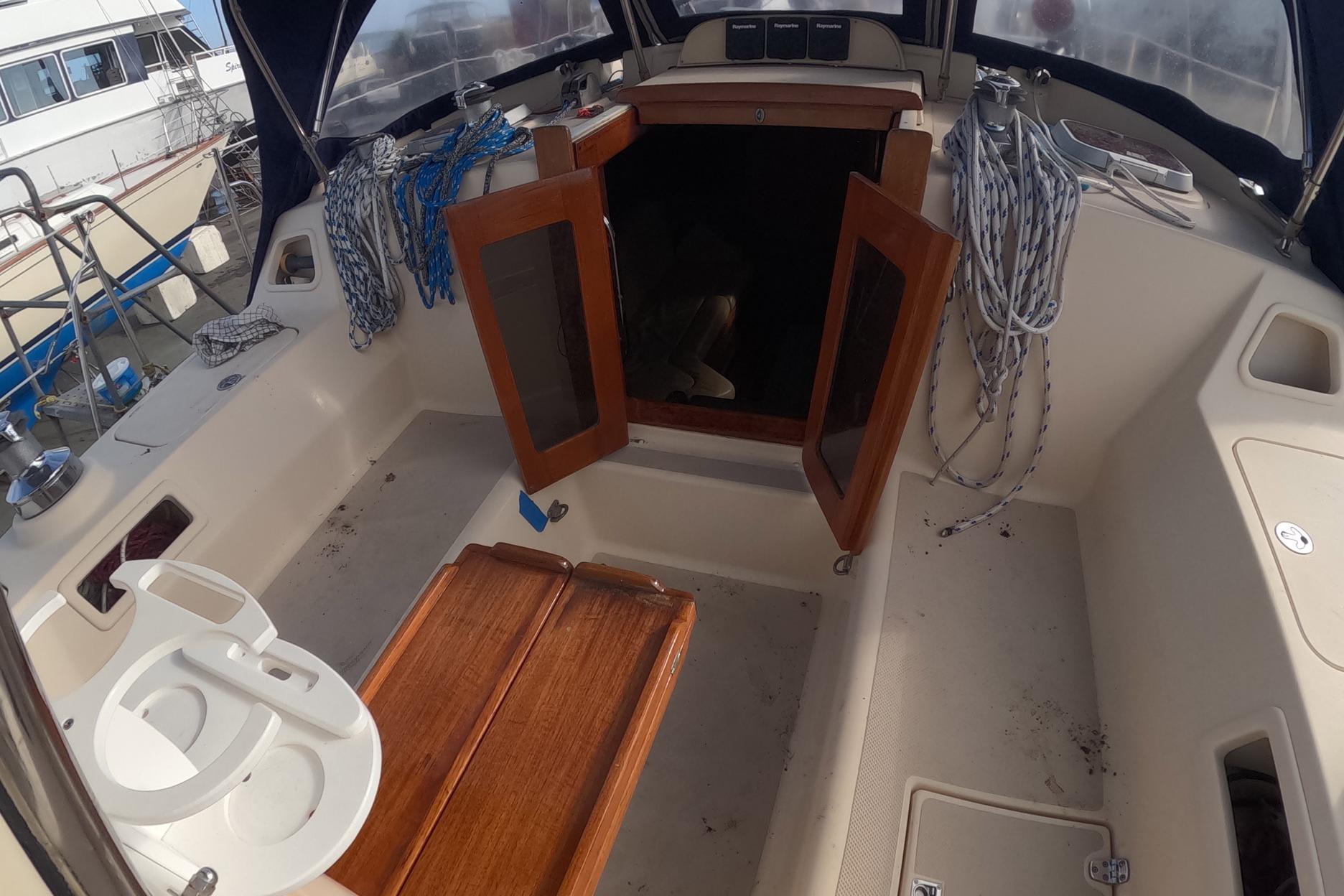 2005 Island Packet 370 sailboat cockpit with open wooden doors and coiled ropes.