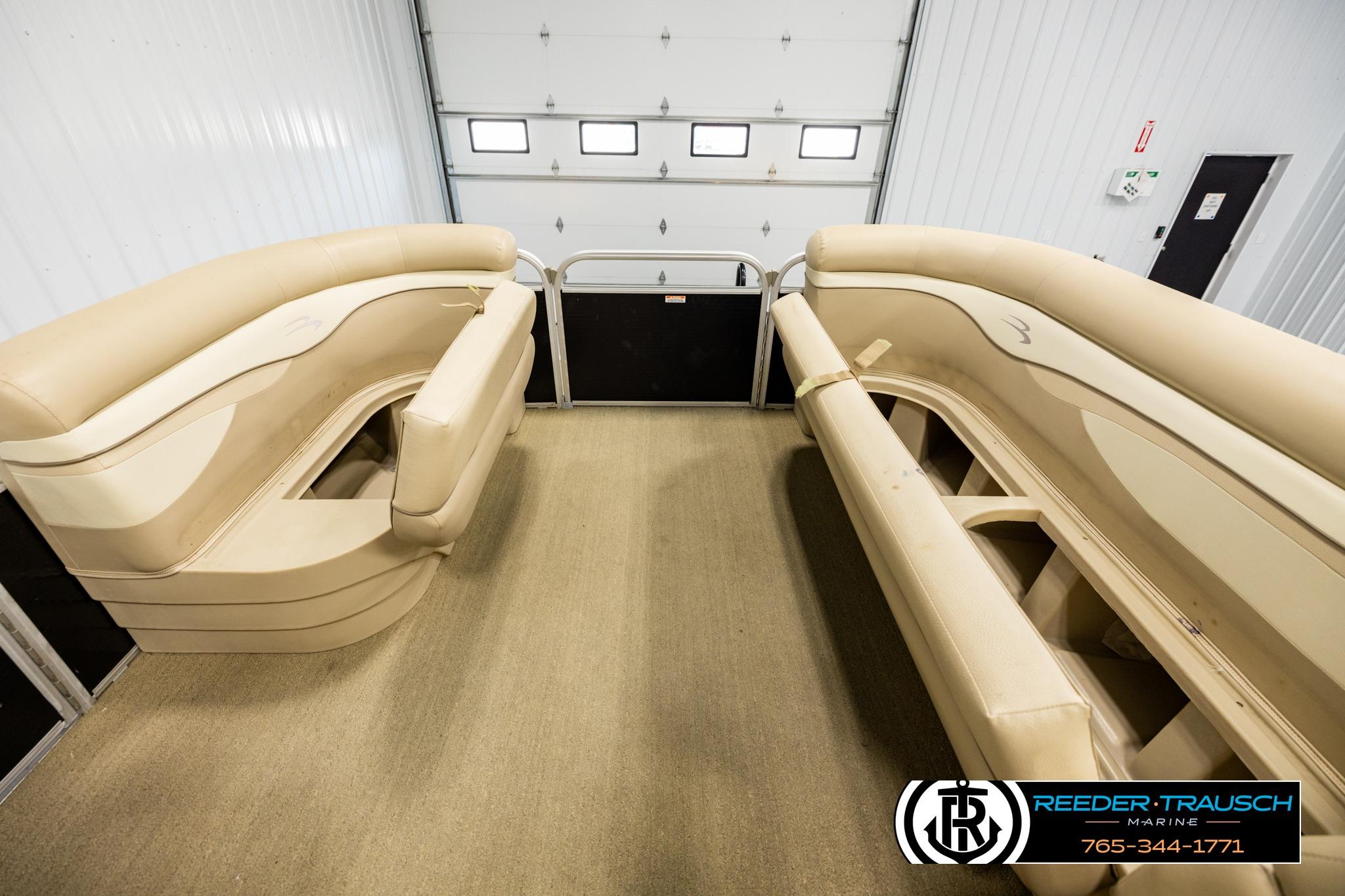 Interior view of a 2013 Bennington 20 SLMX pontoon boat with beige seating.