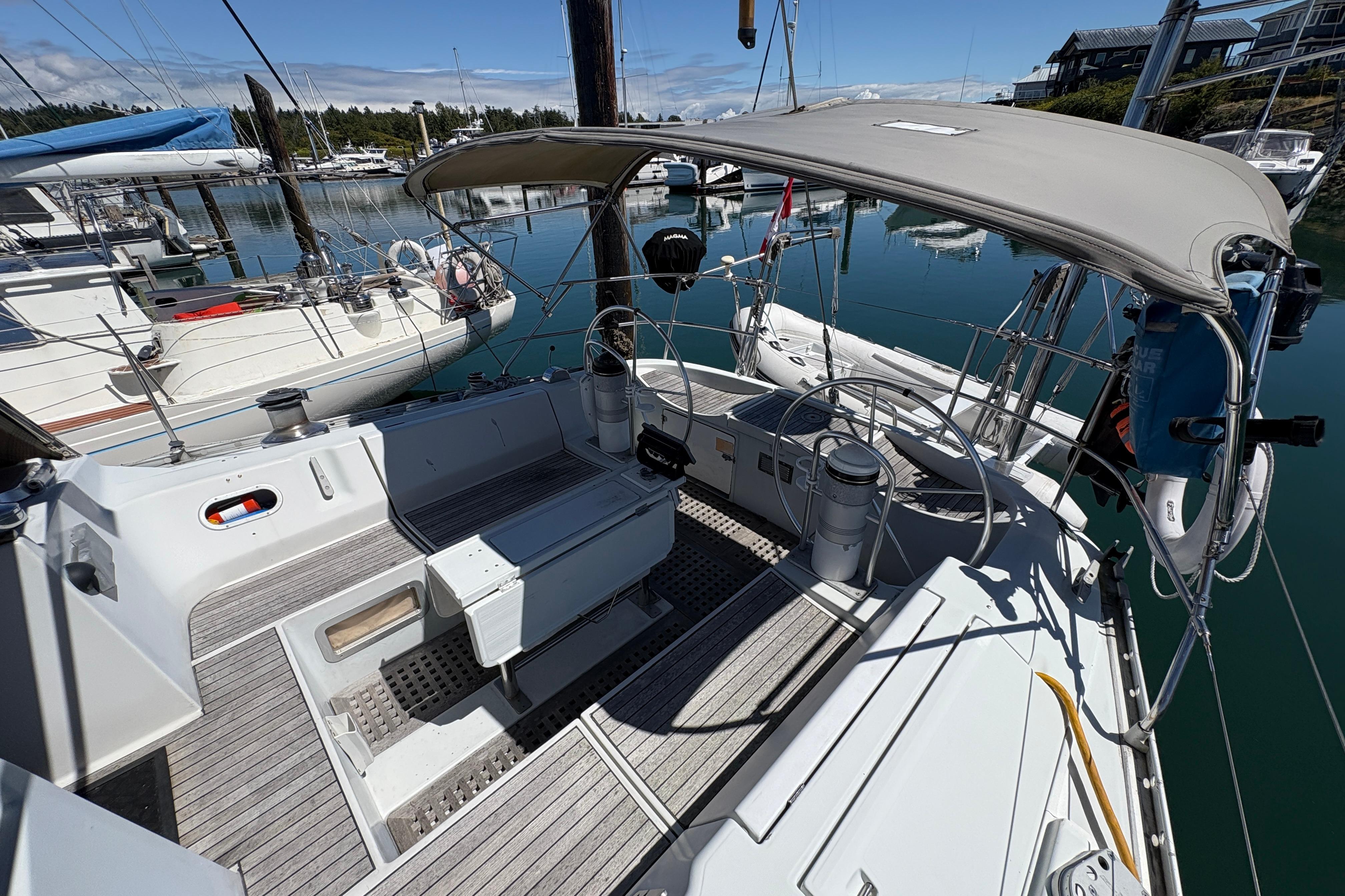 1990 Beneteau Oceanis 500 sailboat cockpit with canopy, docked in a marina.