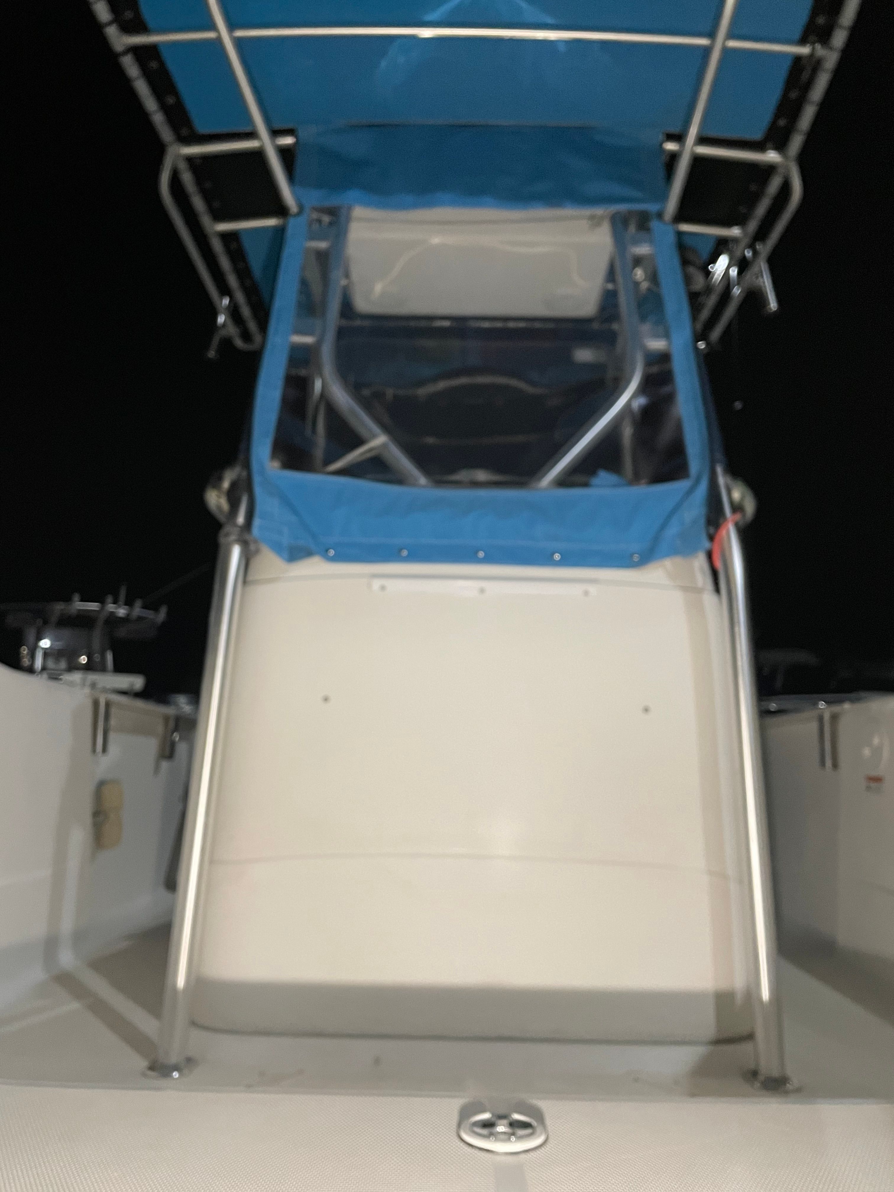 2005 Aquasport 210 Osprey boat with blue canopy at night.