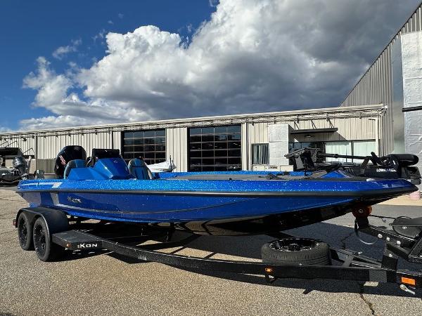 2024 iKon LX 20 blue boat on trailer outside industrial building.