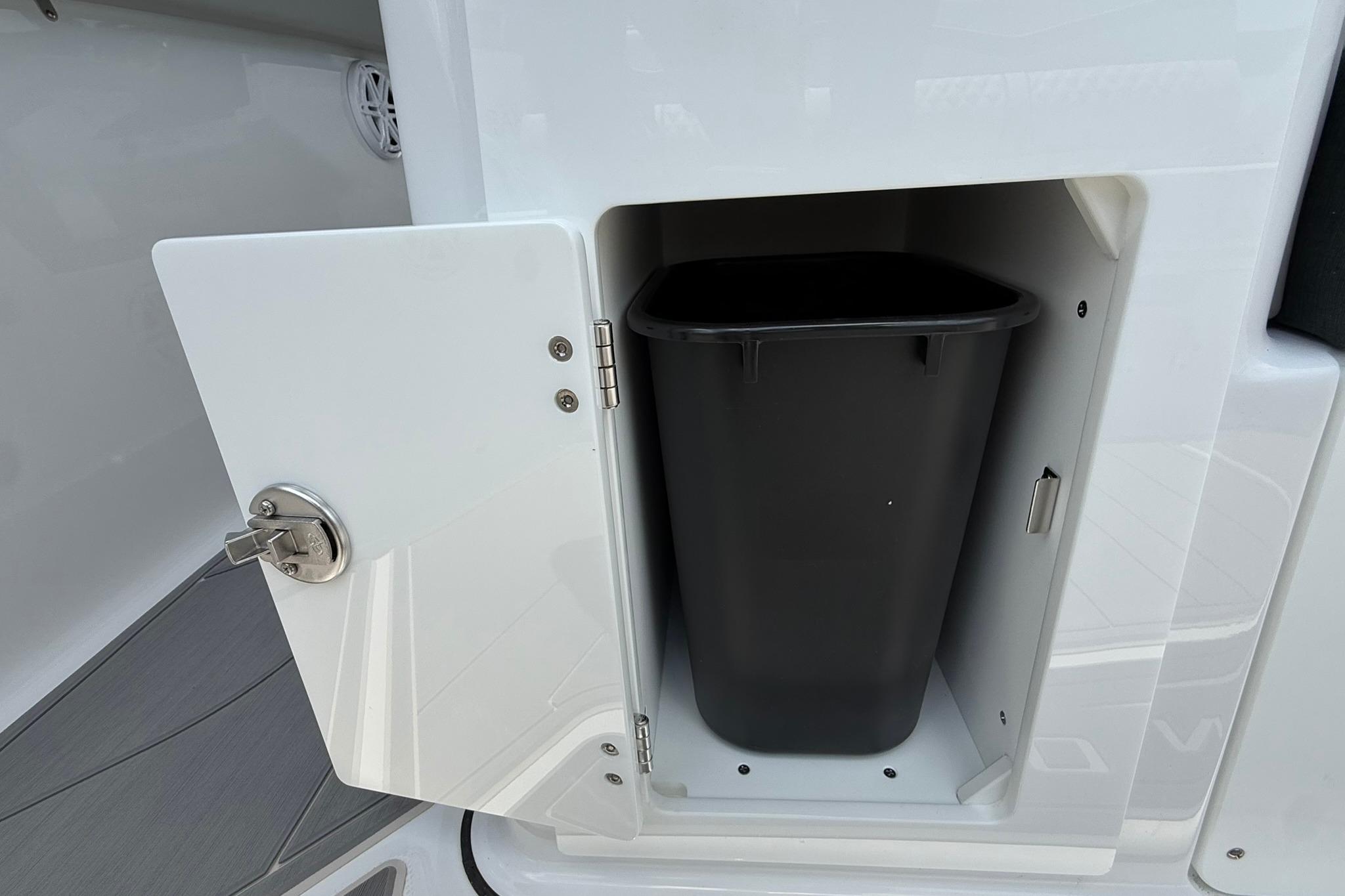 Storage compartment with trash bin on 2027 Monterey Elite 30 OB boat.