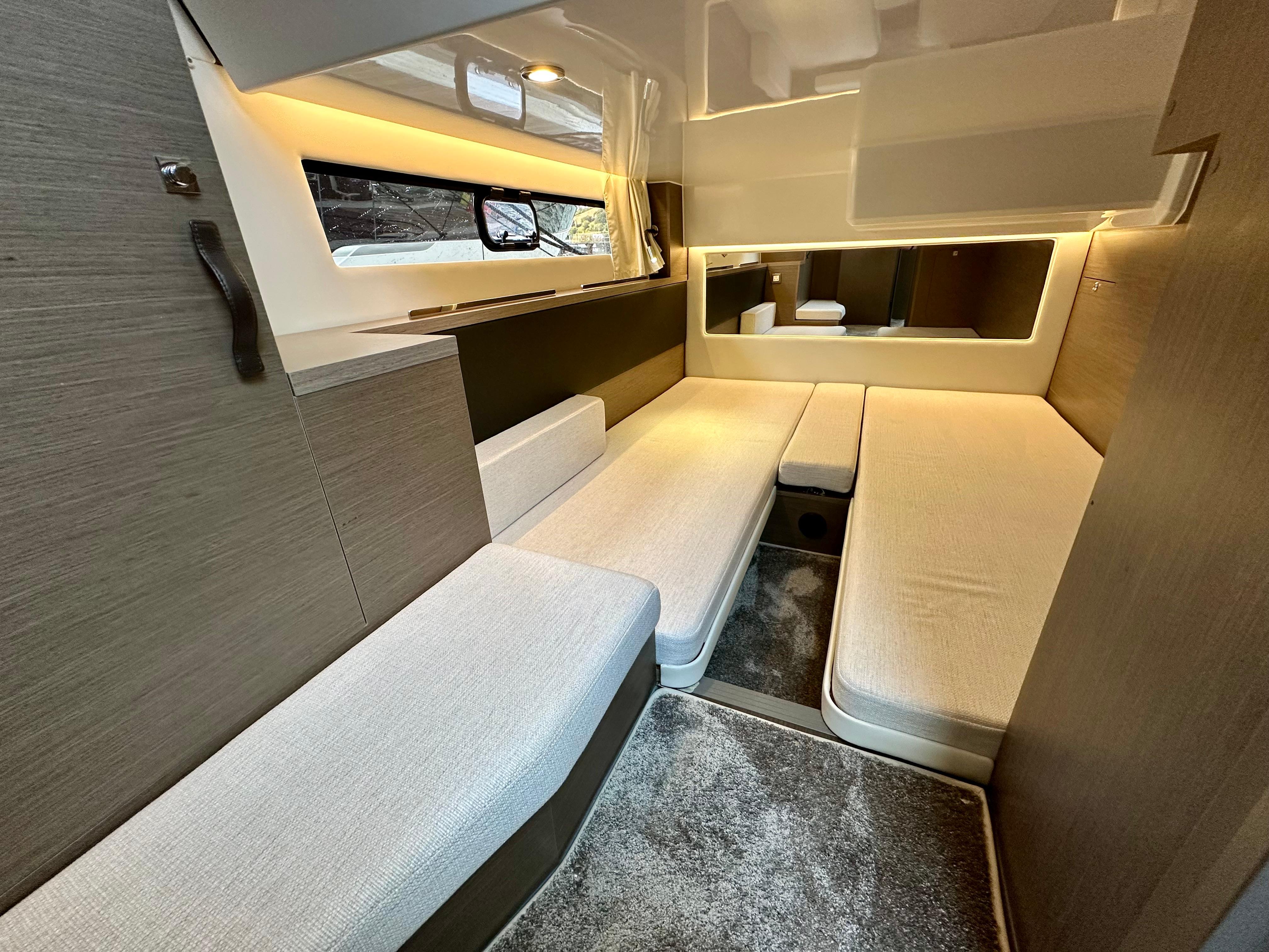 2024 Jeanneau Merry Fisher 1295 Flybridge interior with modern seating and ambient lighting.
