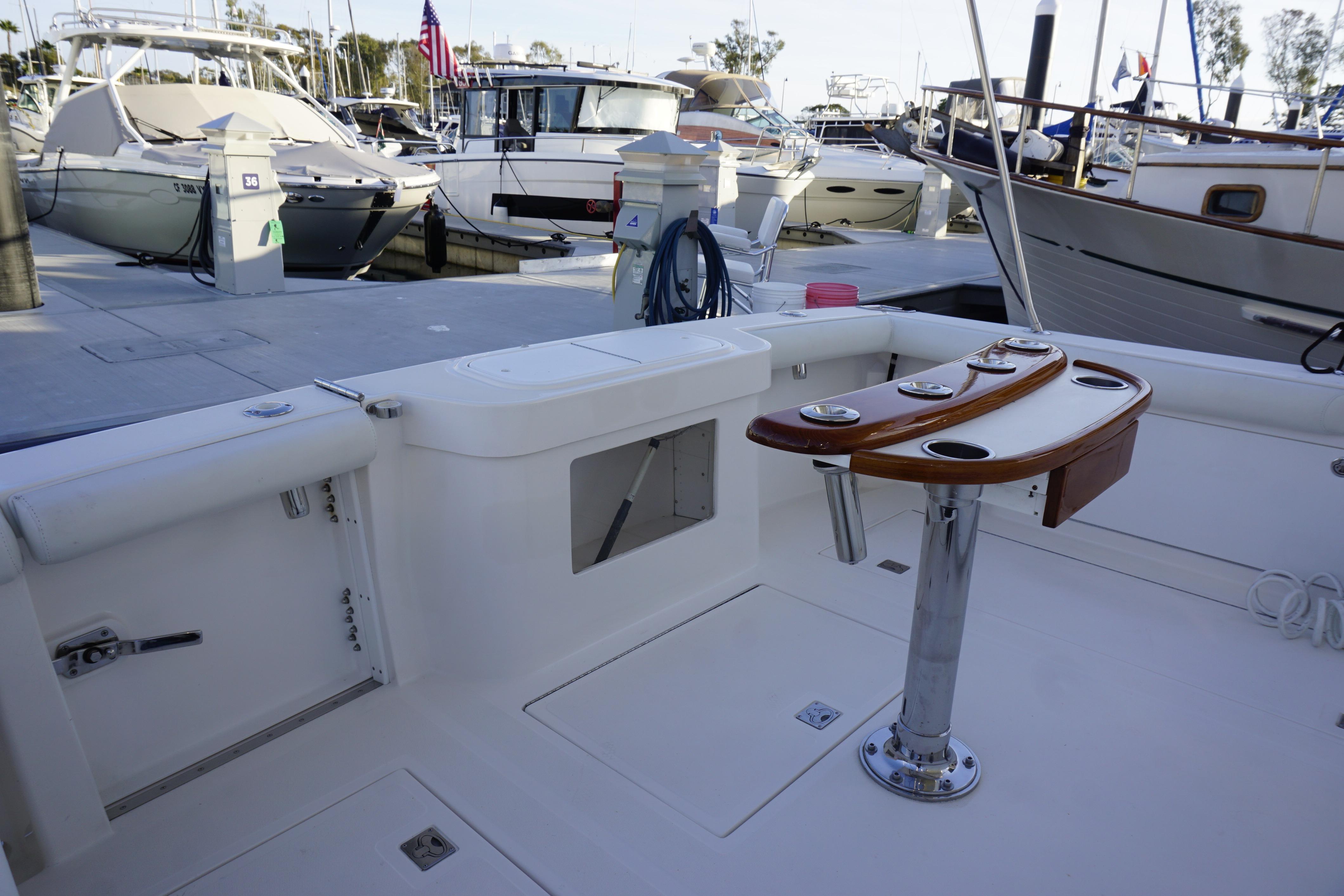 2005 Cabo 35 Express boat docked, featuring a clean deck and fishing rod holders.