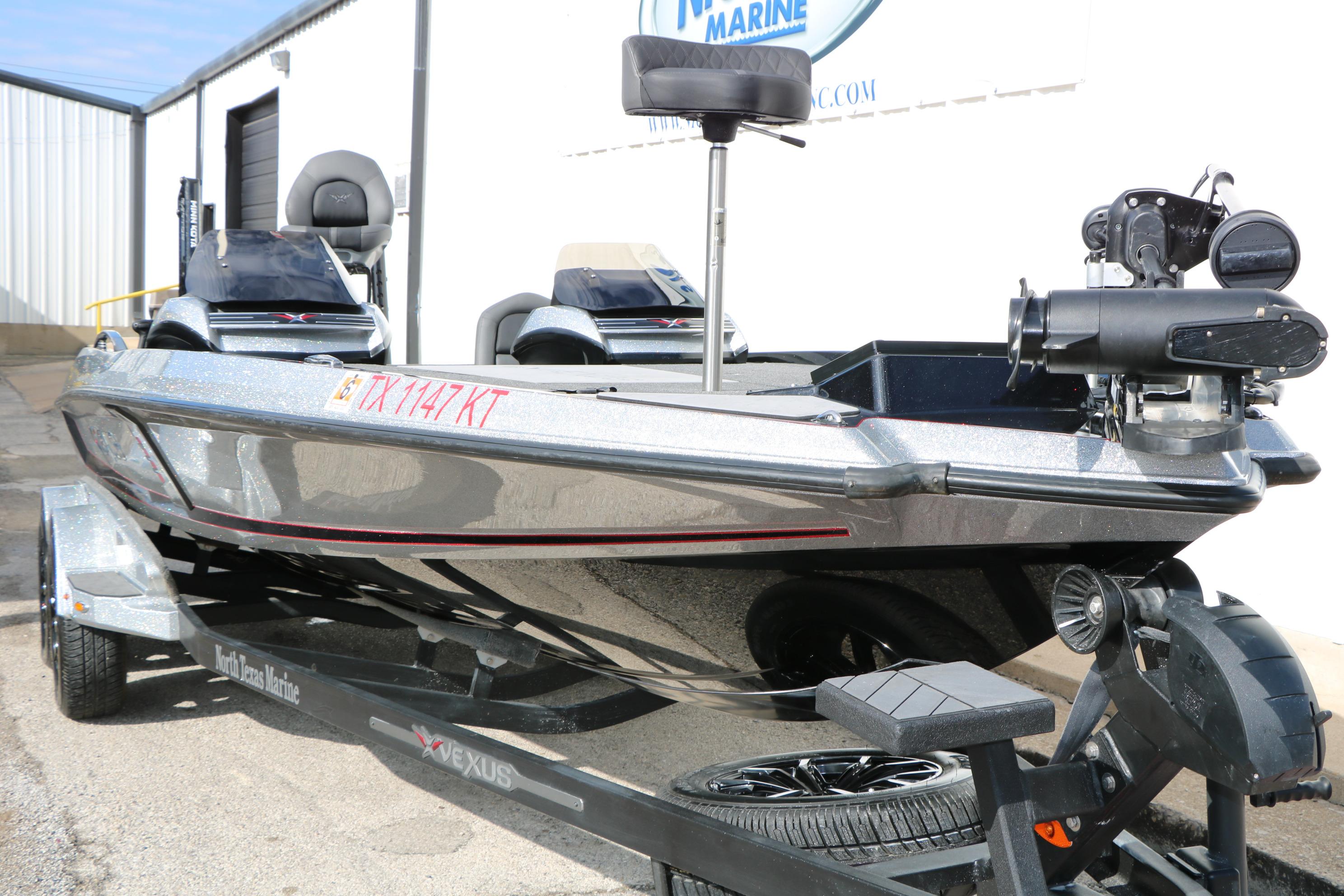 2022 Vexus VX21 boat on trailer, silver finish, parked outside a marine facility.