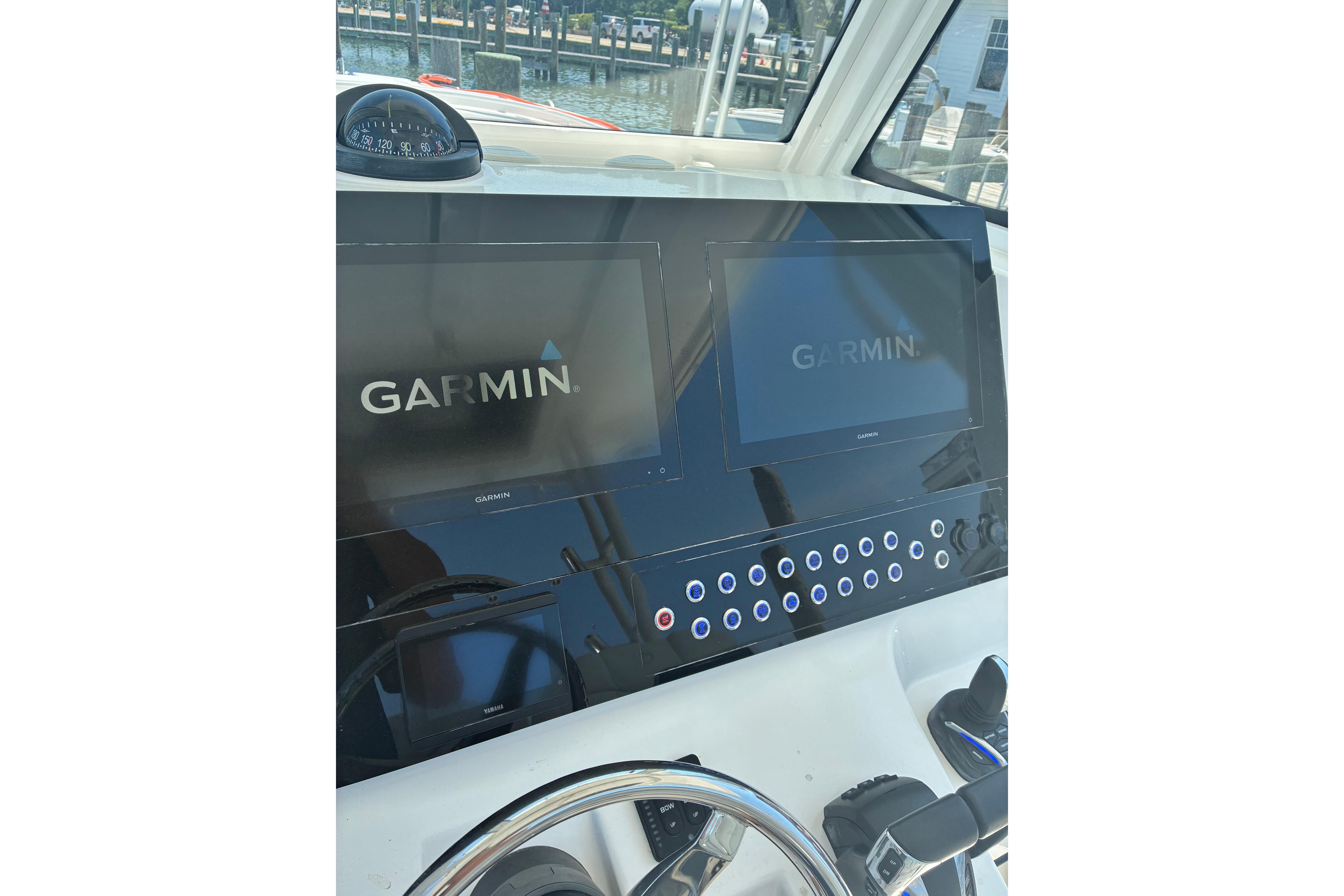 Dashboard of 2023 Edgewater 285CC boat with Garmin displays and controls.