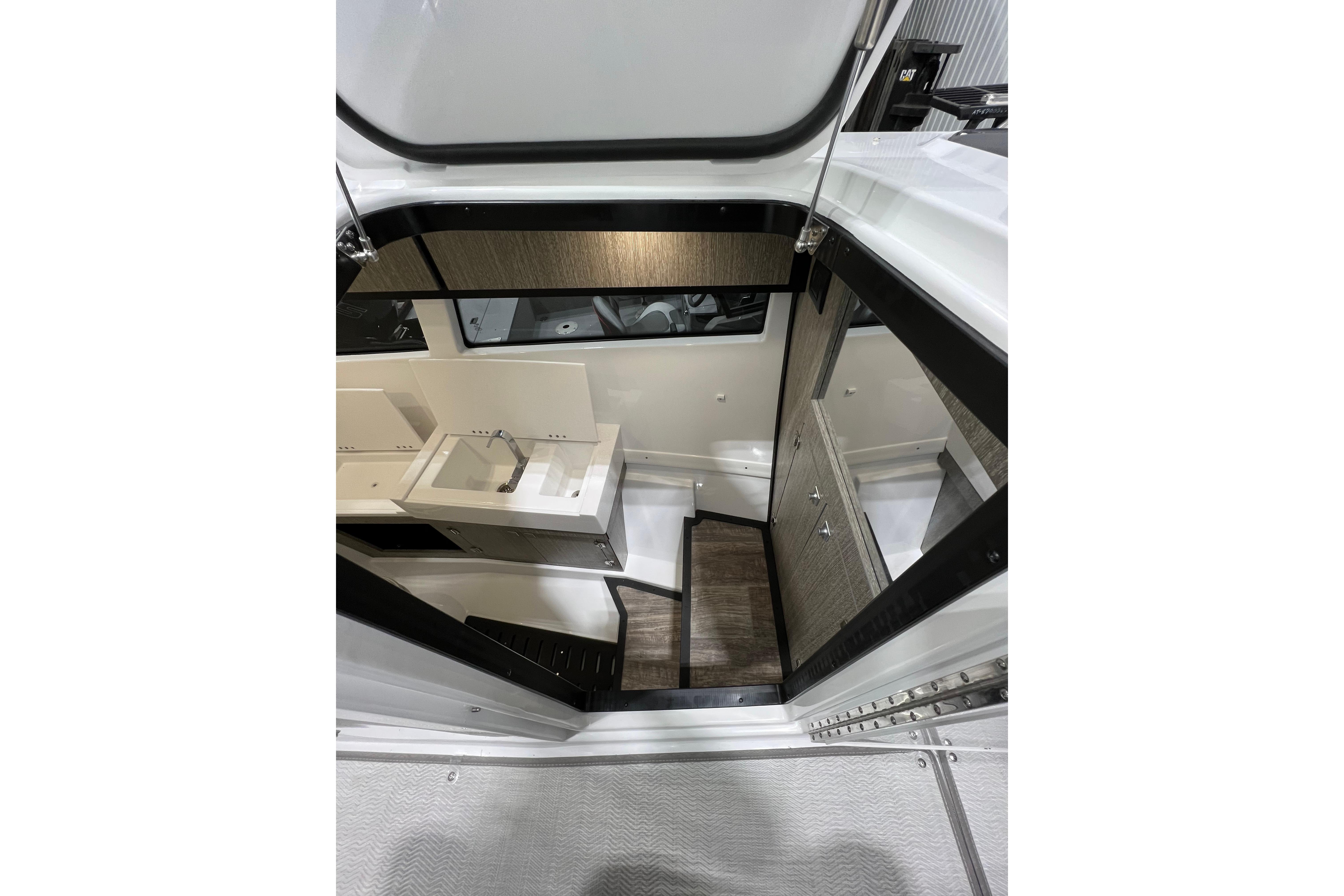 Interior view of 2023 Monterey 378SS Super Sport boat cabin with sink and stairs.