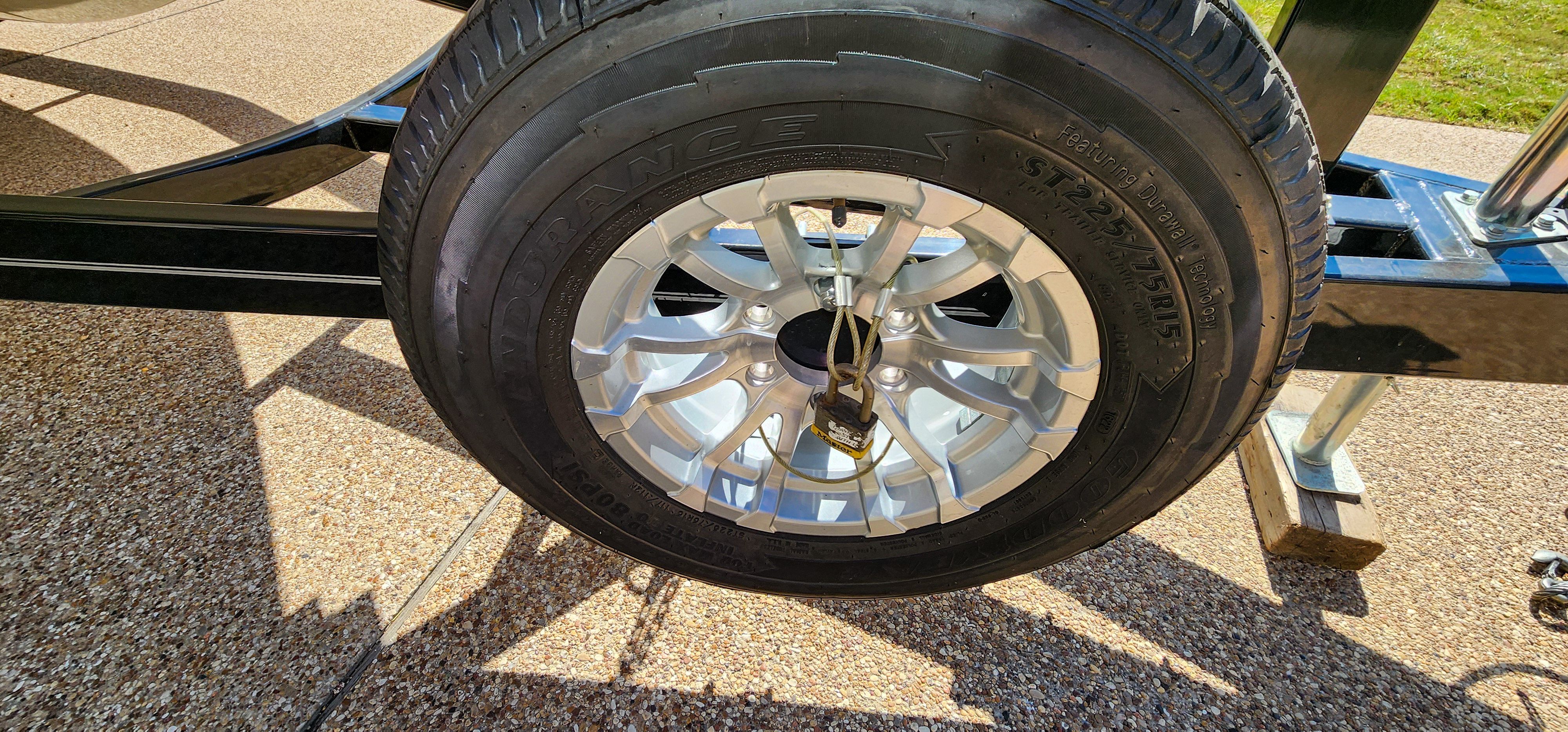 Close-up of a boat trailer wheel with a silver rim and black tire.