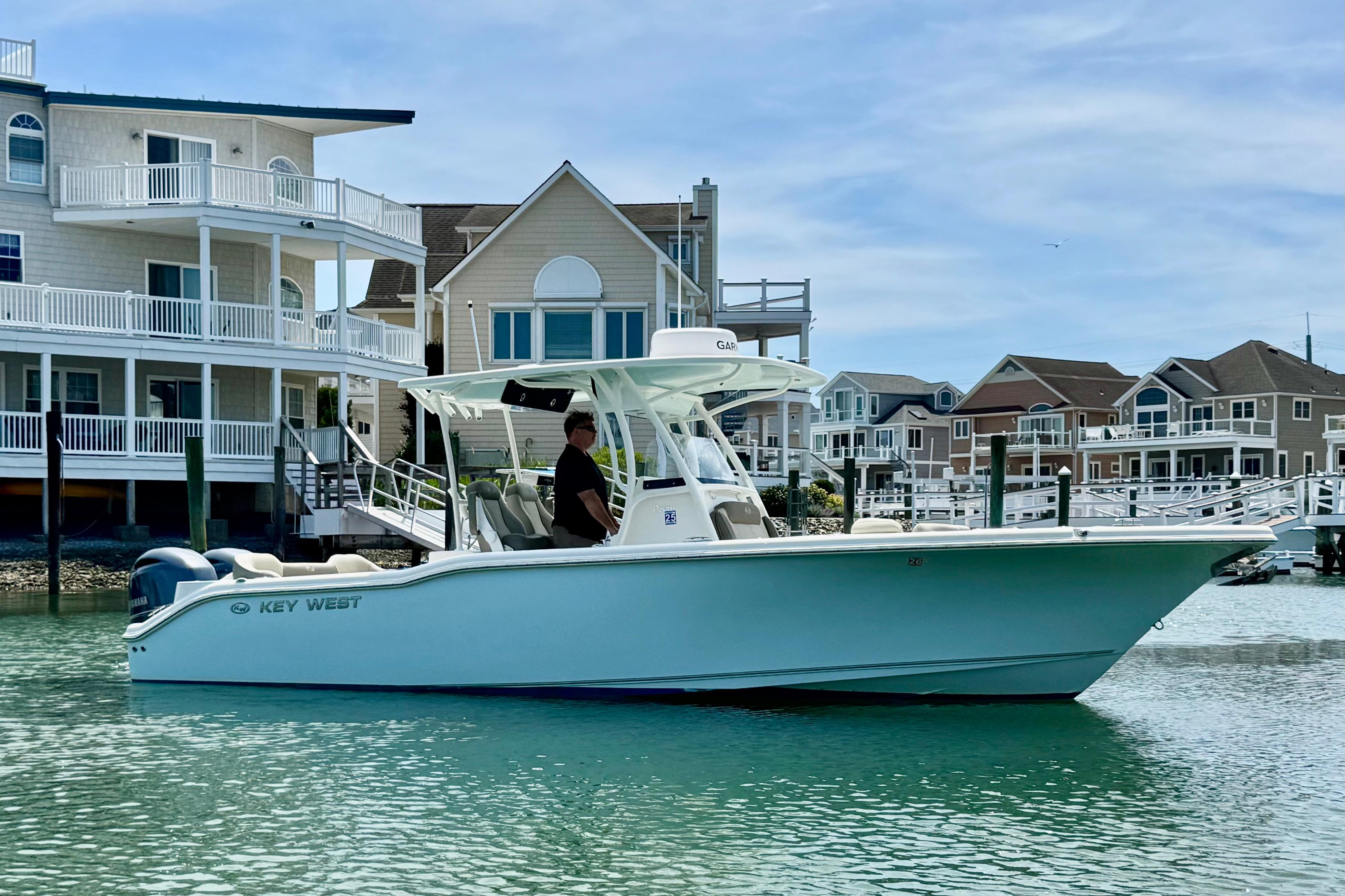 2022 Key West 263 FS boat cruising near waterfront homes on a sunny day.