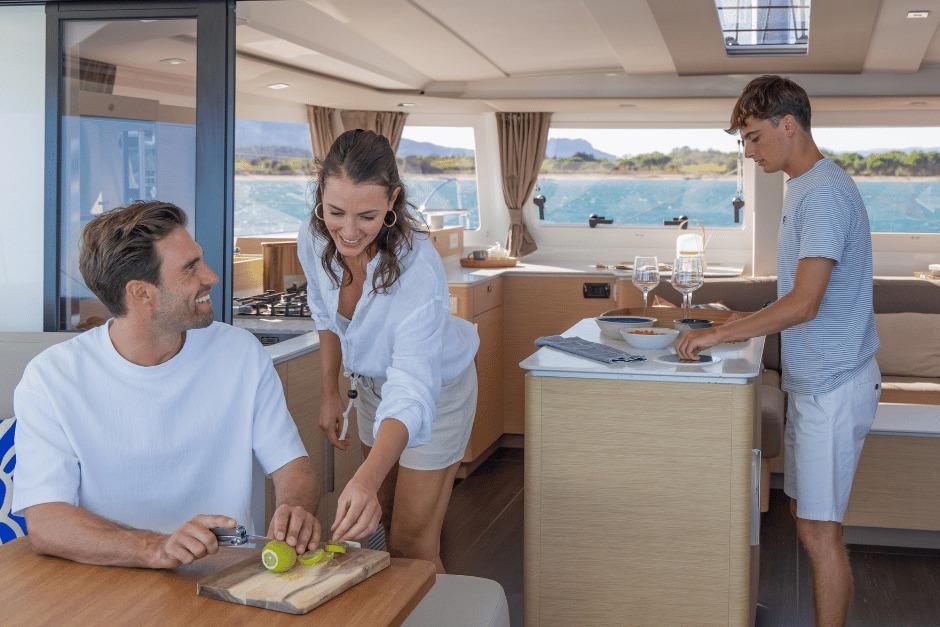People enjoying a meal preparation inside a 2026 Fountaine Pajot 44 catamaran.