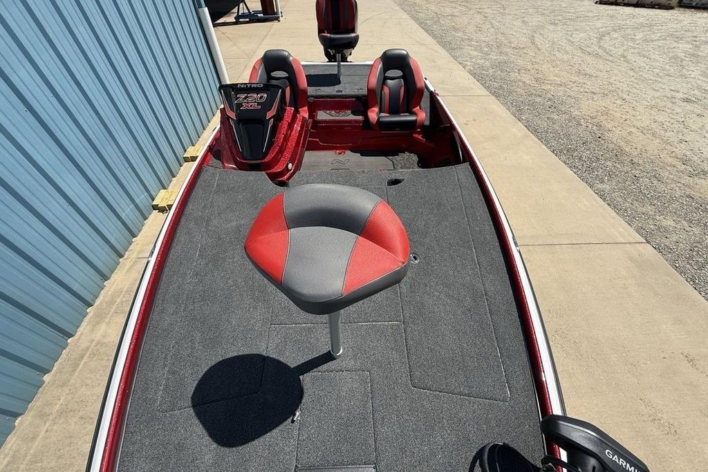 2026 Nitro Z20 XL Pro boat with red and gray seating, parked near a blue building.