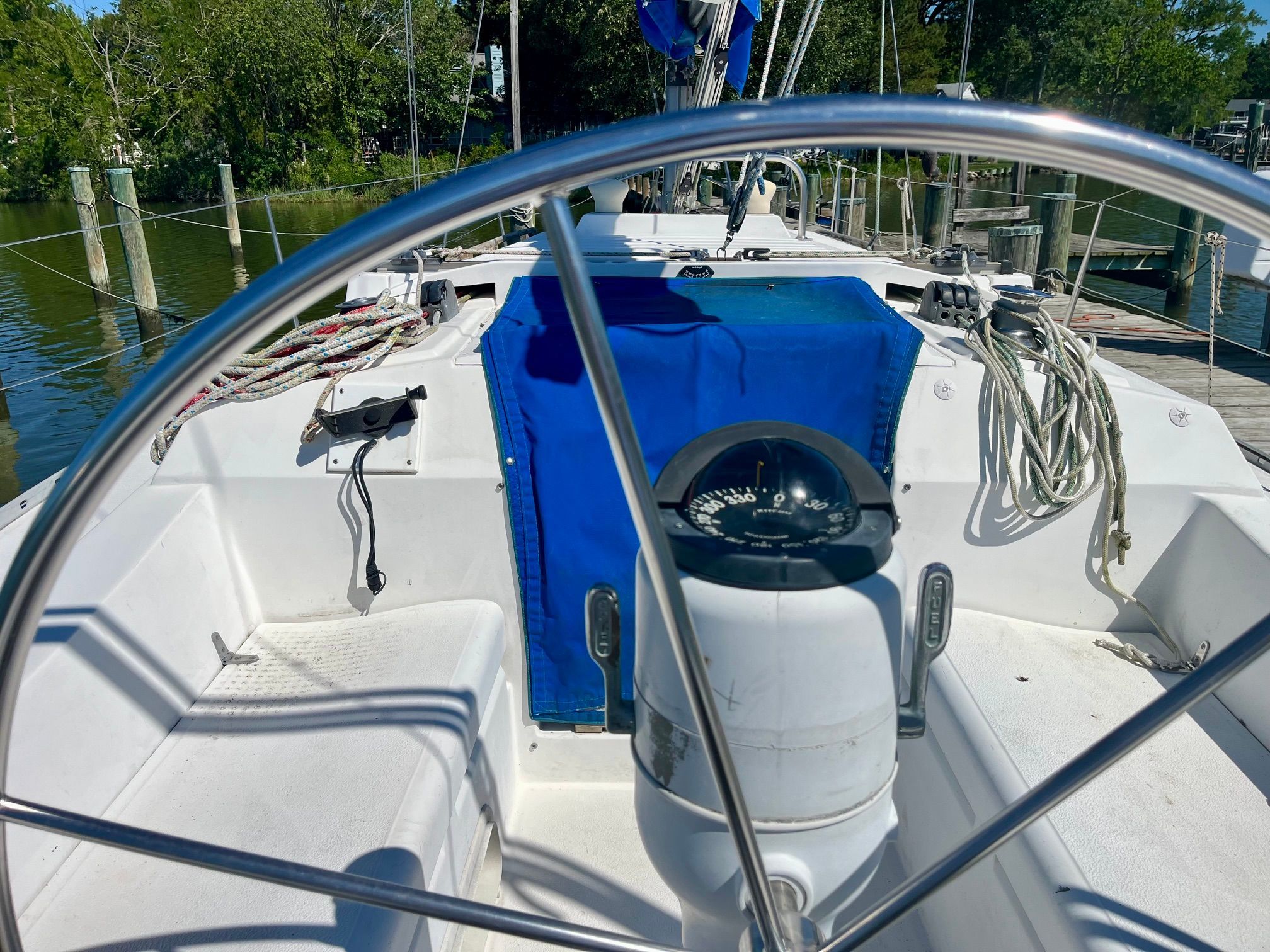 The image shows the cockpit of a 1985 Hunter 30 with a steering wheel and compass.