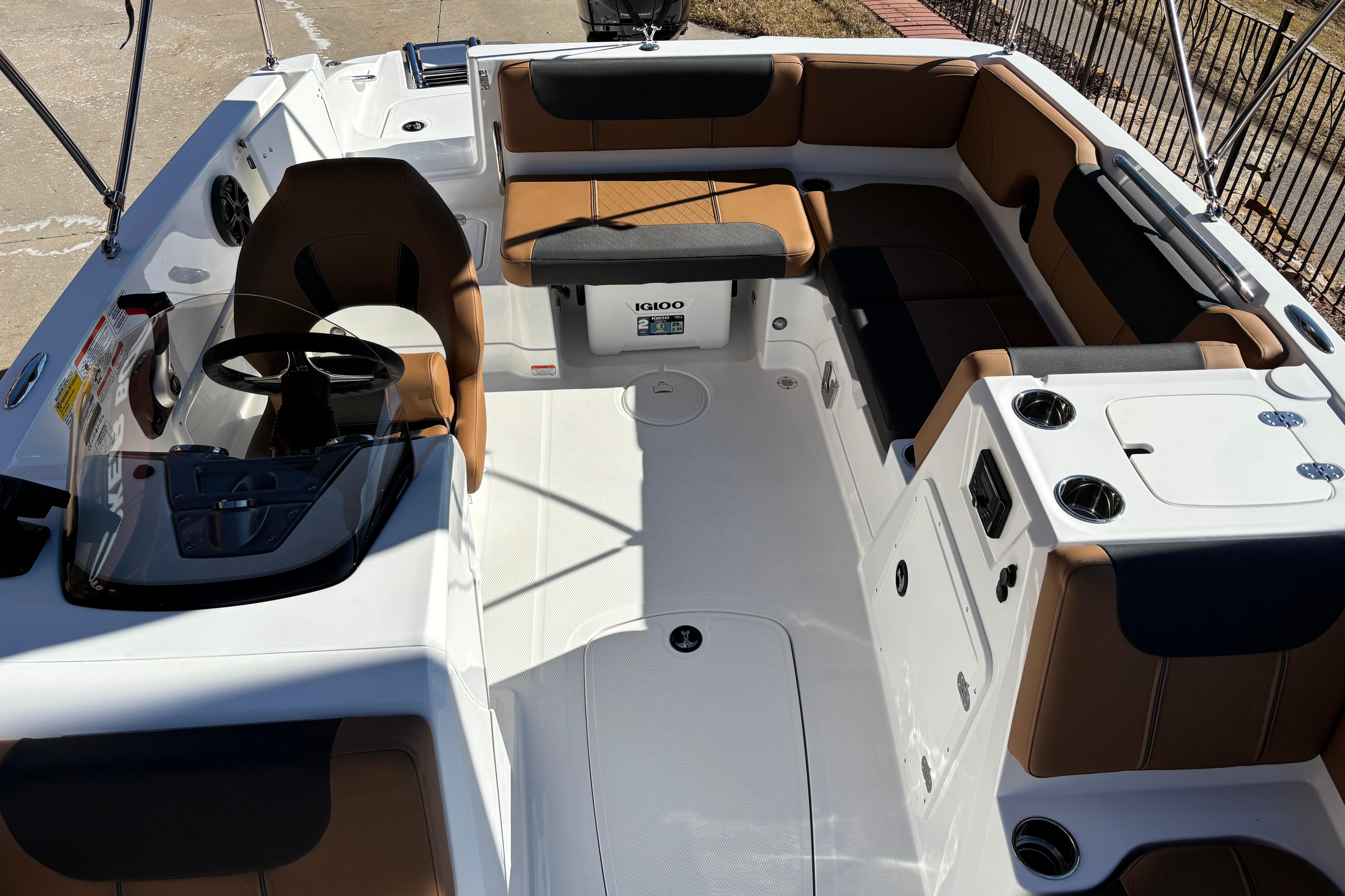 2026 Tahoe 1950 boat interior with brown and black seating, steering console, and cup holders.