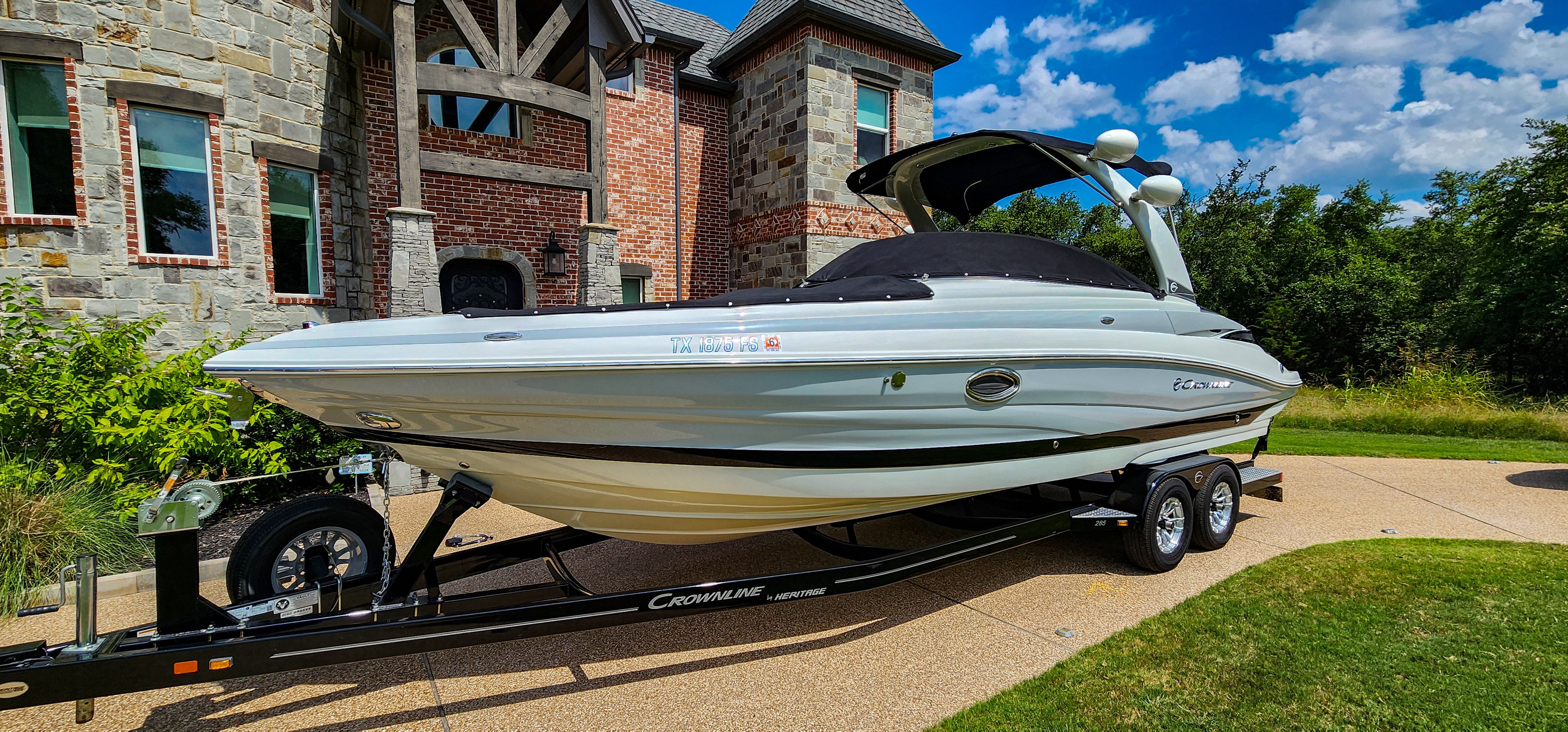 A 2017 Crownline 285SS on a trailer in front of a brick building.