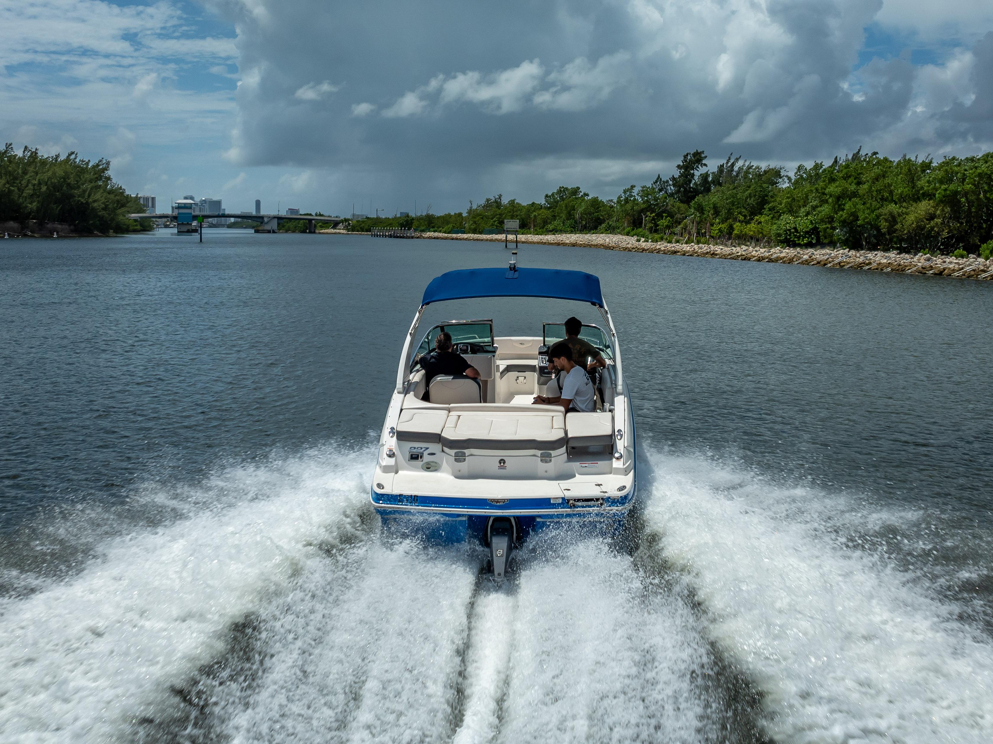 2017 Chaparral 227 SSX boat cruising on a scenic waterway under cloudy skies.