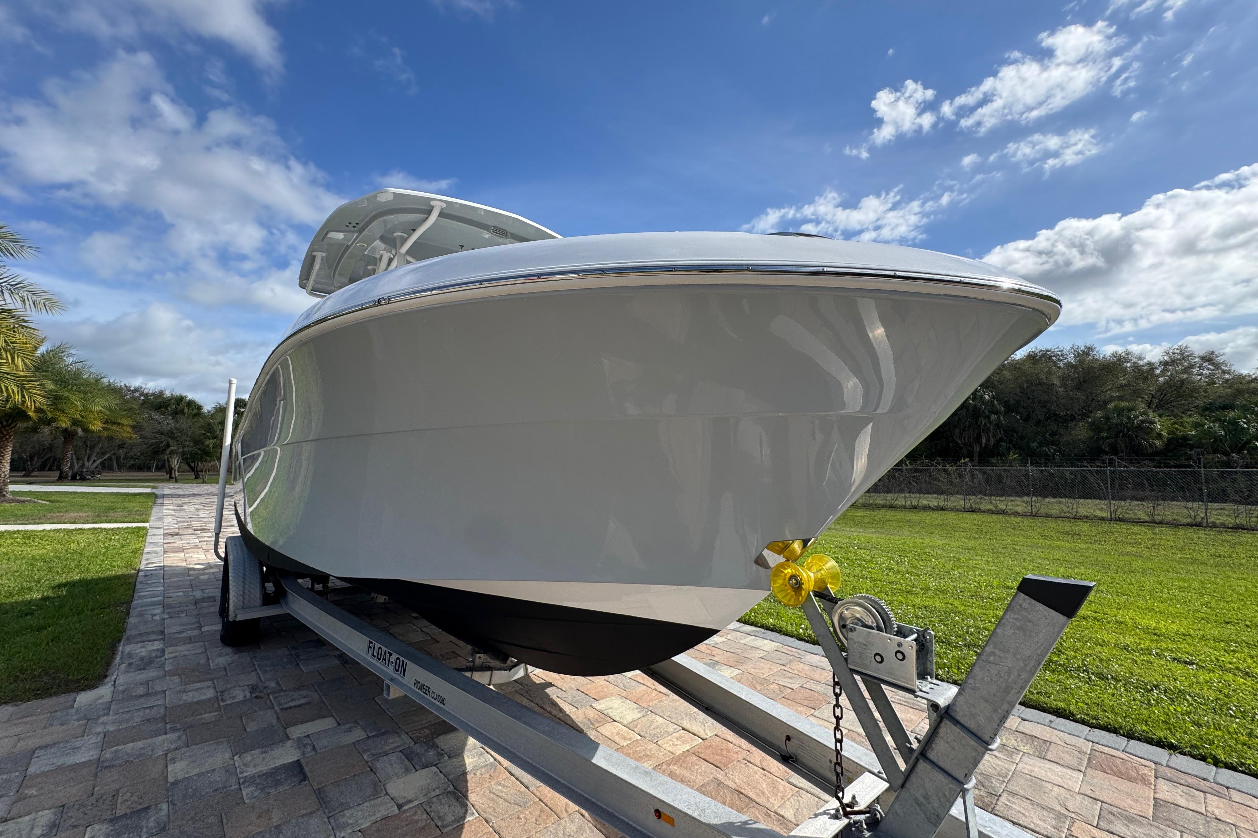 2022 Aquasport 2500 Center Console boat on trailer, under a clear blue sky.