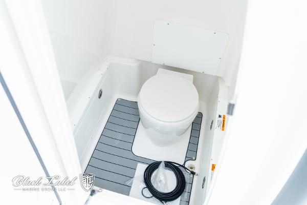 2025 Caymas 281 HB boat interior bathroom with toilet and floor mat.