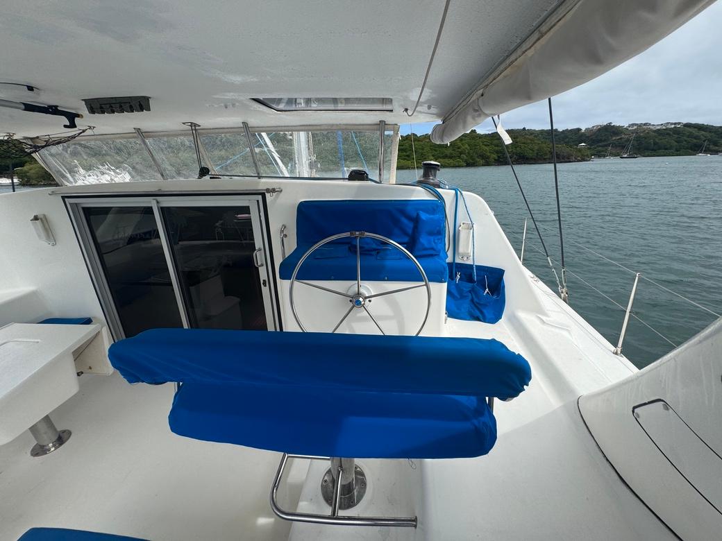 2010 Admiral 38 Executive yacht with blue seating and steering wheel, docked by the water.