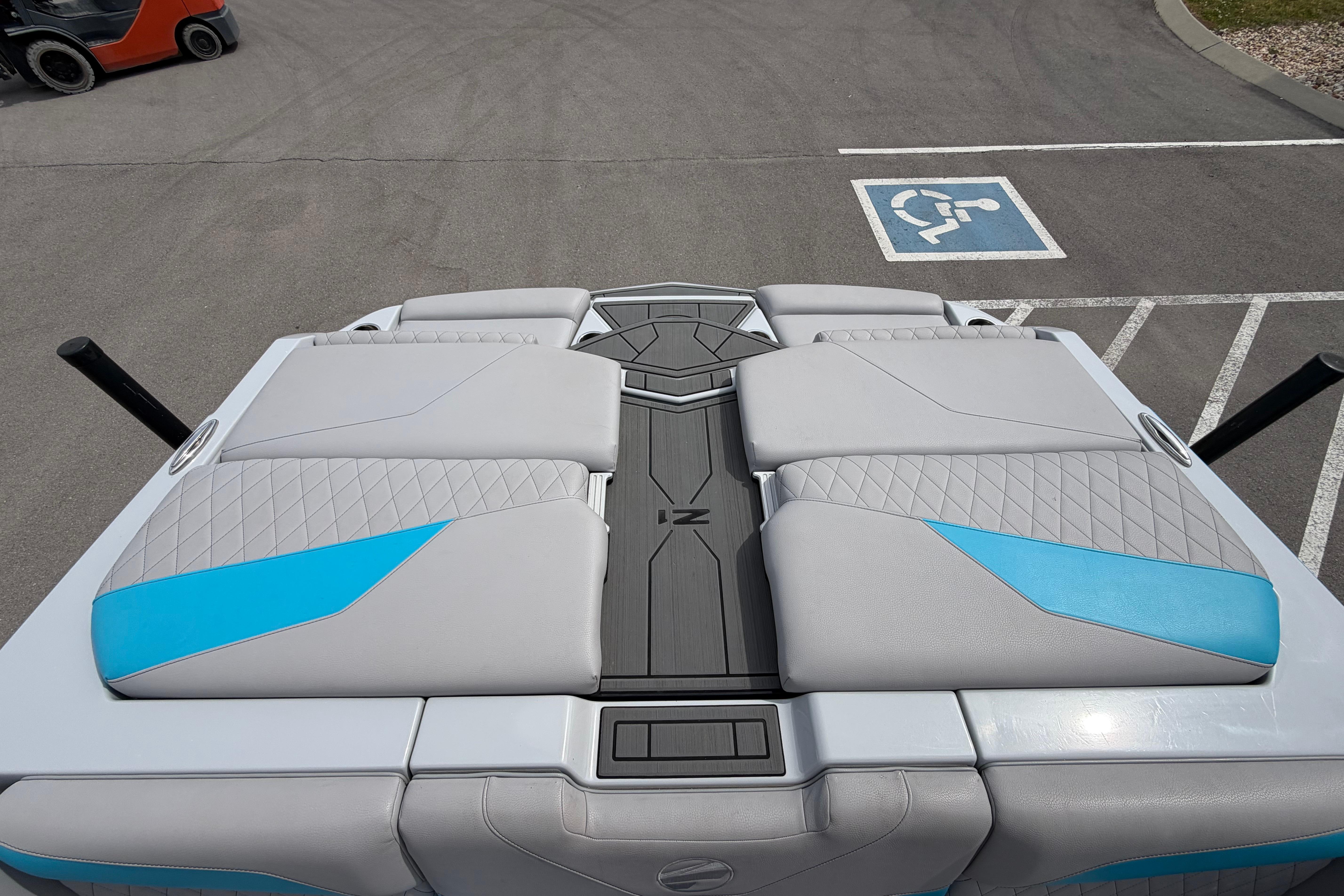 2024 Tigé Z1 boat interior with gray and blue seating, parked near a handicap space.
