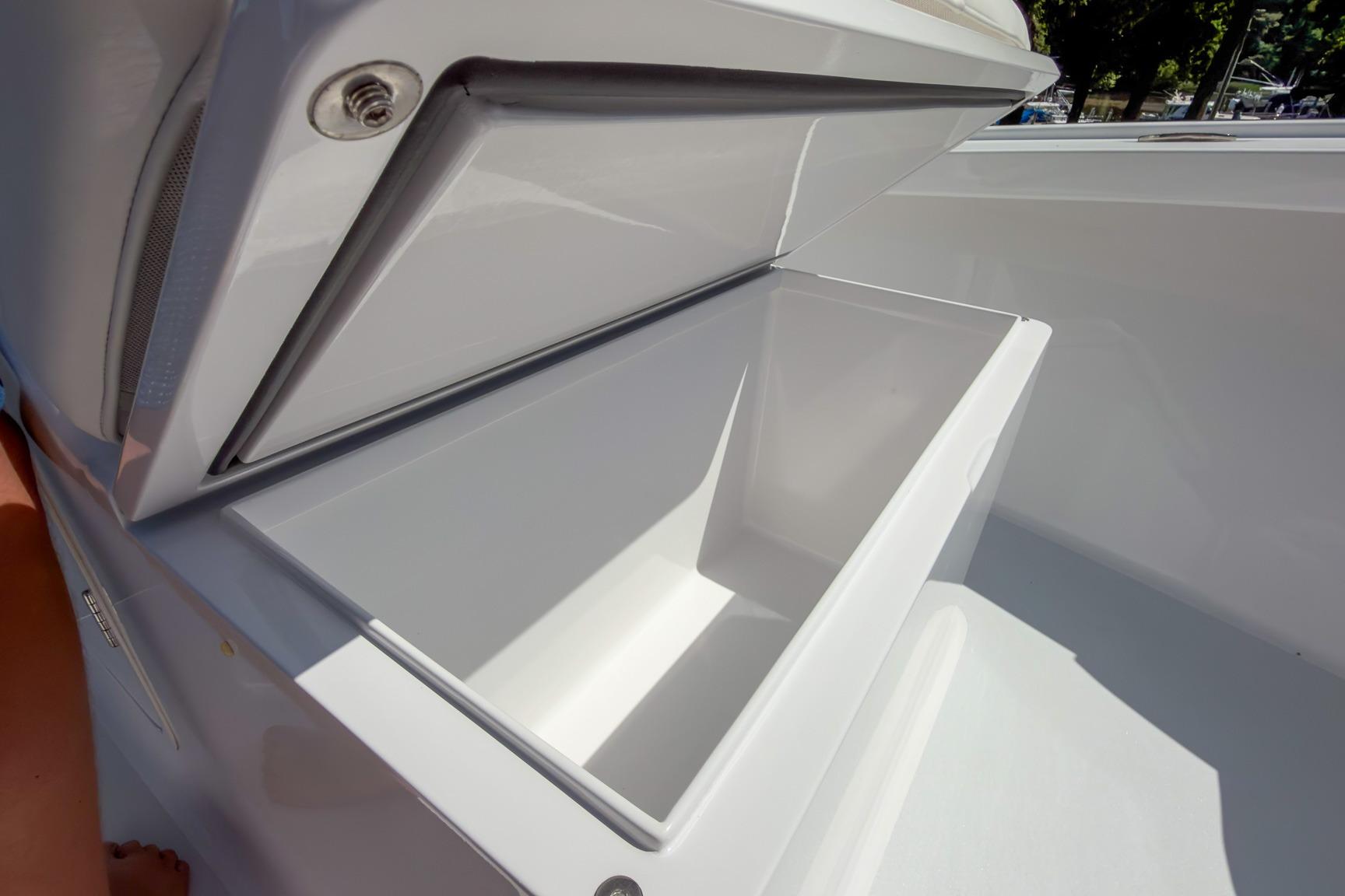Open storage compartment on a 2025 Weaver 25 boat, showcasing sleek design.