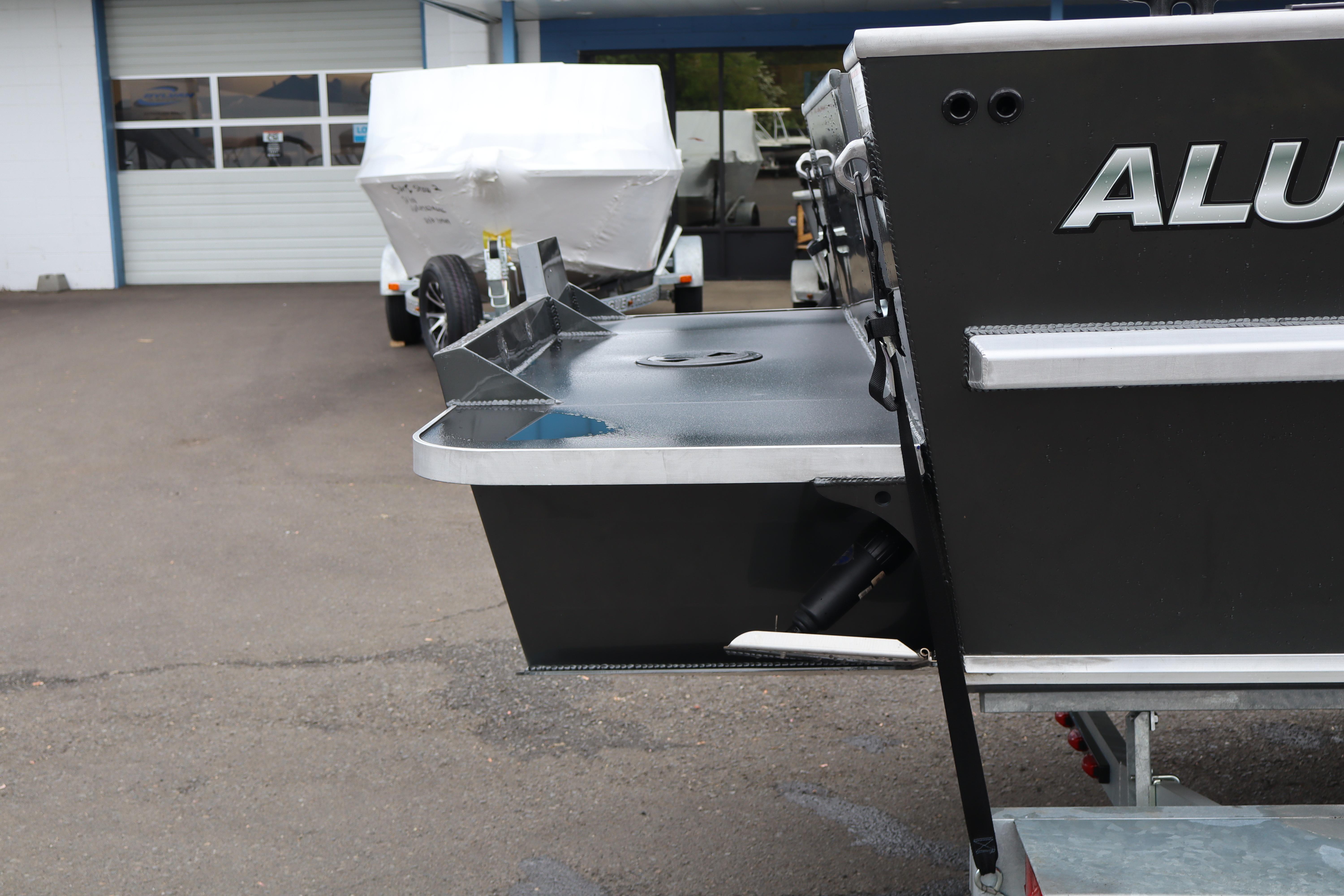 2026 Alumaweld Horizon 24 boat rear view in a parking lot.