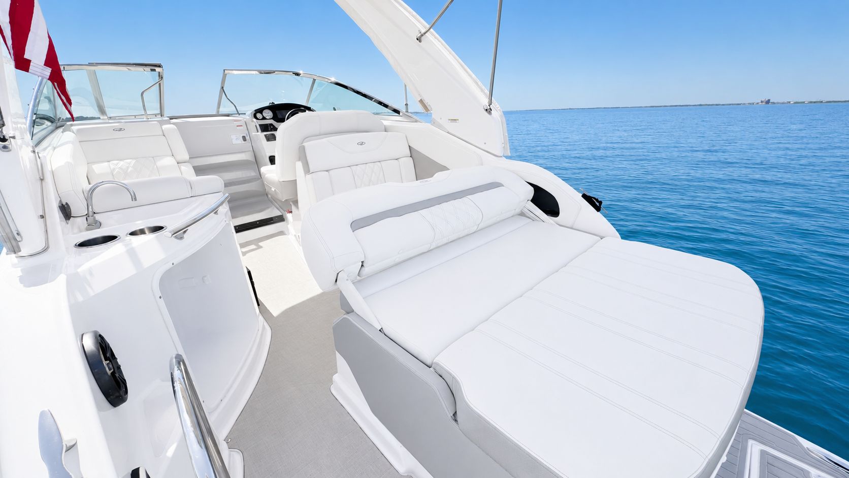 Regal 28 Express 2020: Luxurious cockpit with white upholstery on calm water.