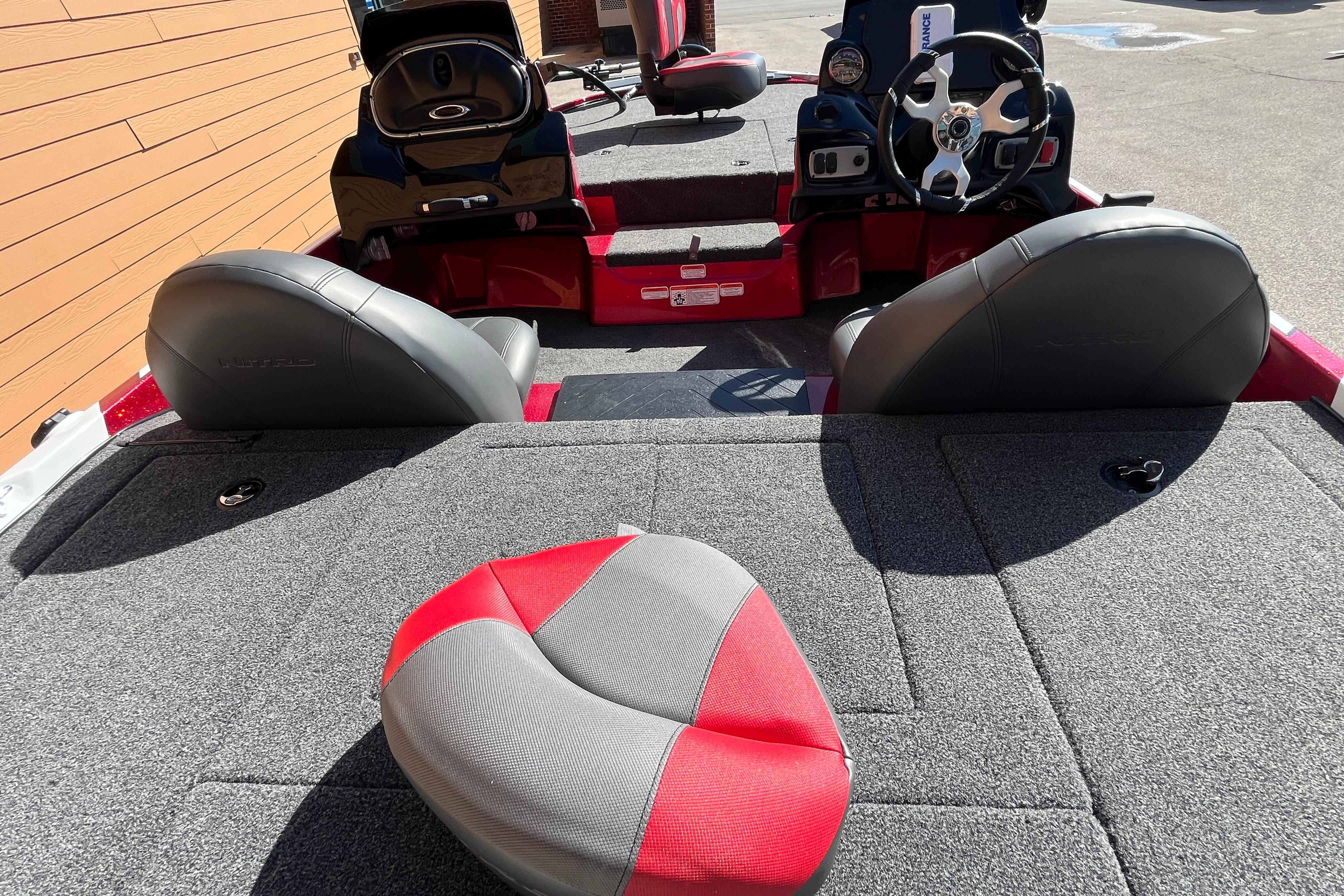 Interior of a 2026 Nitro Z17 boat featuring gray and red seating and steering console.