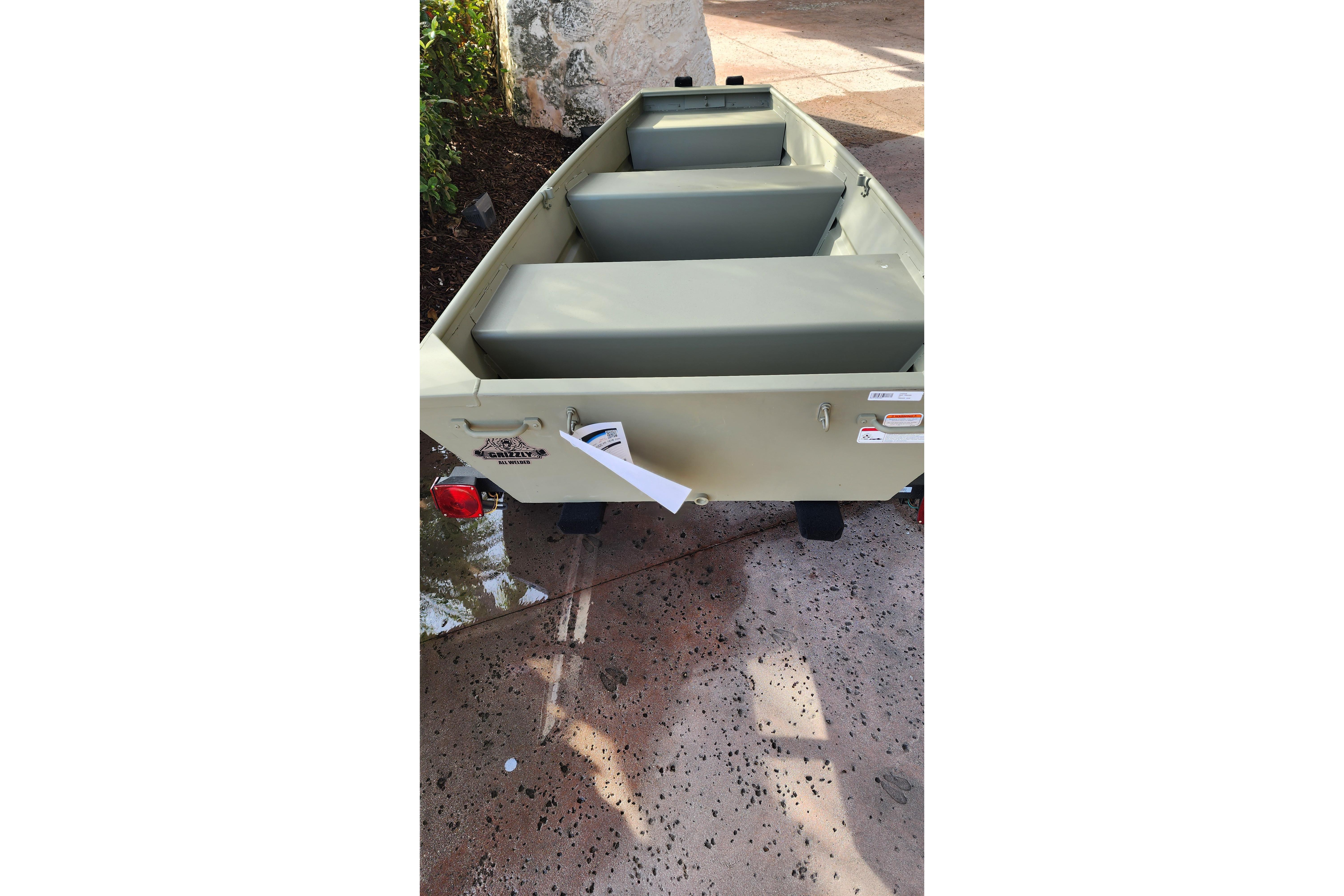 2026 Tracker Grizzly 10 Jon boat on pavement, featuring three bench seats.