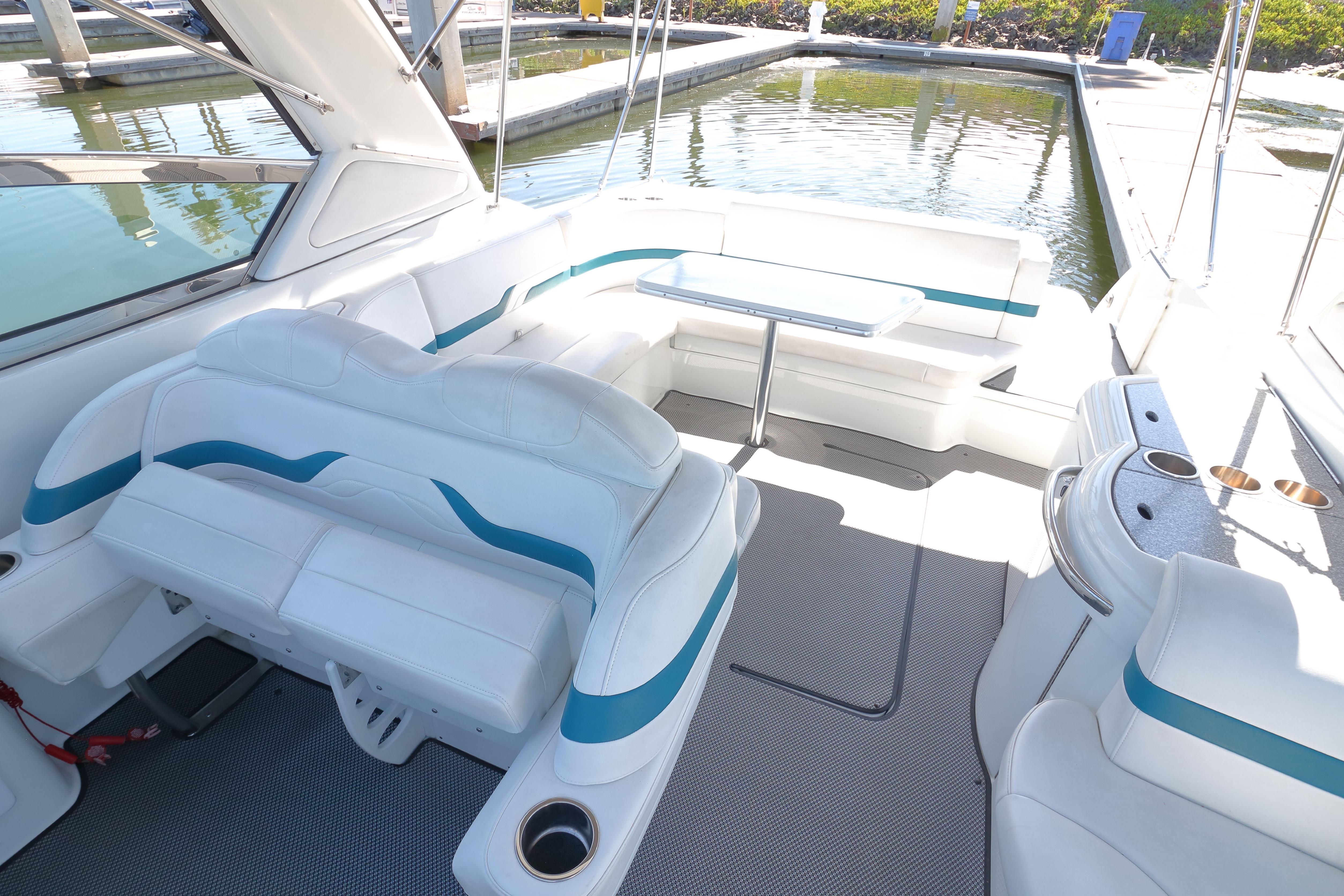 2006 Formula 330 Sun Sport boat interior with white seating and table, docked by water.